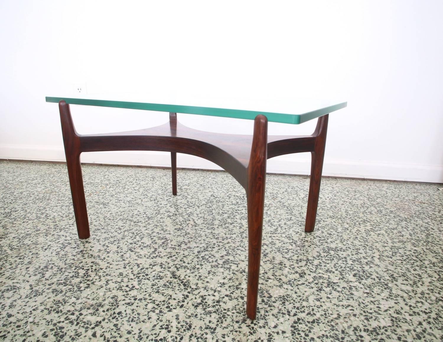Rare Danish teak and glass coffee table by Sven Ellekaer, circa 1960. The original smooth rimmed glass top sits on notched teak wood leg posts.