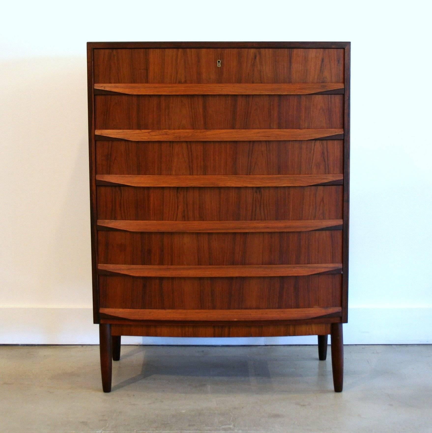 A beautiful six-drawer dresser in Brazilian rosewood with conical legs and unique drawer pulls on dove-tailed drawers. This piece features an exquisite wood grain and dark edge detailing.