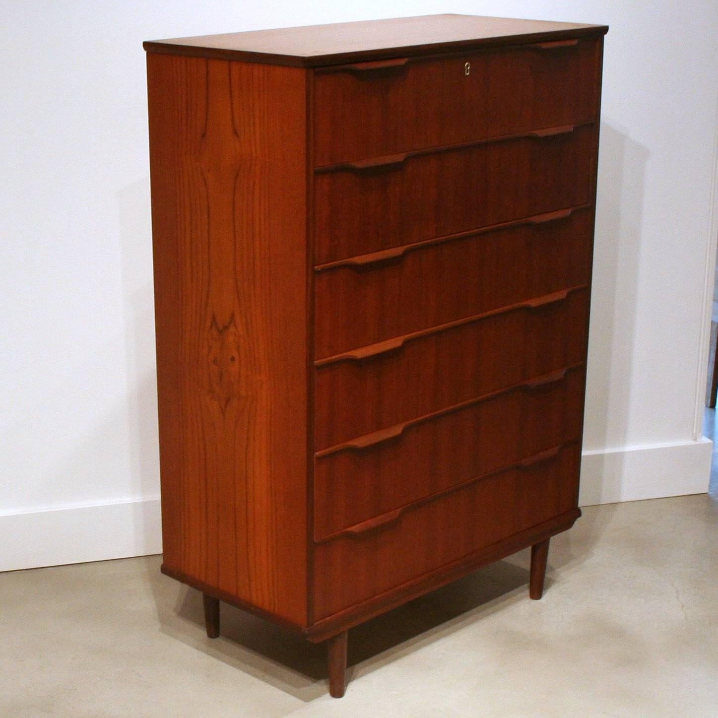 Stunning teak dresser featuring conical teak legs, crafted drawer pulls, and dove-tail construction. These dressers add character and warmth to your modern bedroom. Made in Denmark.