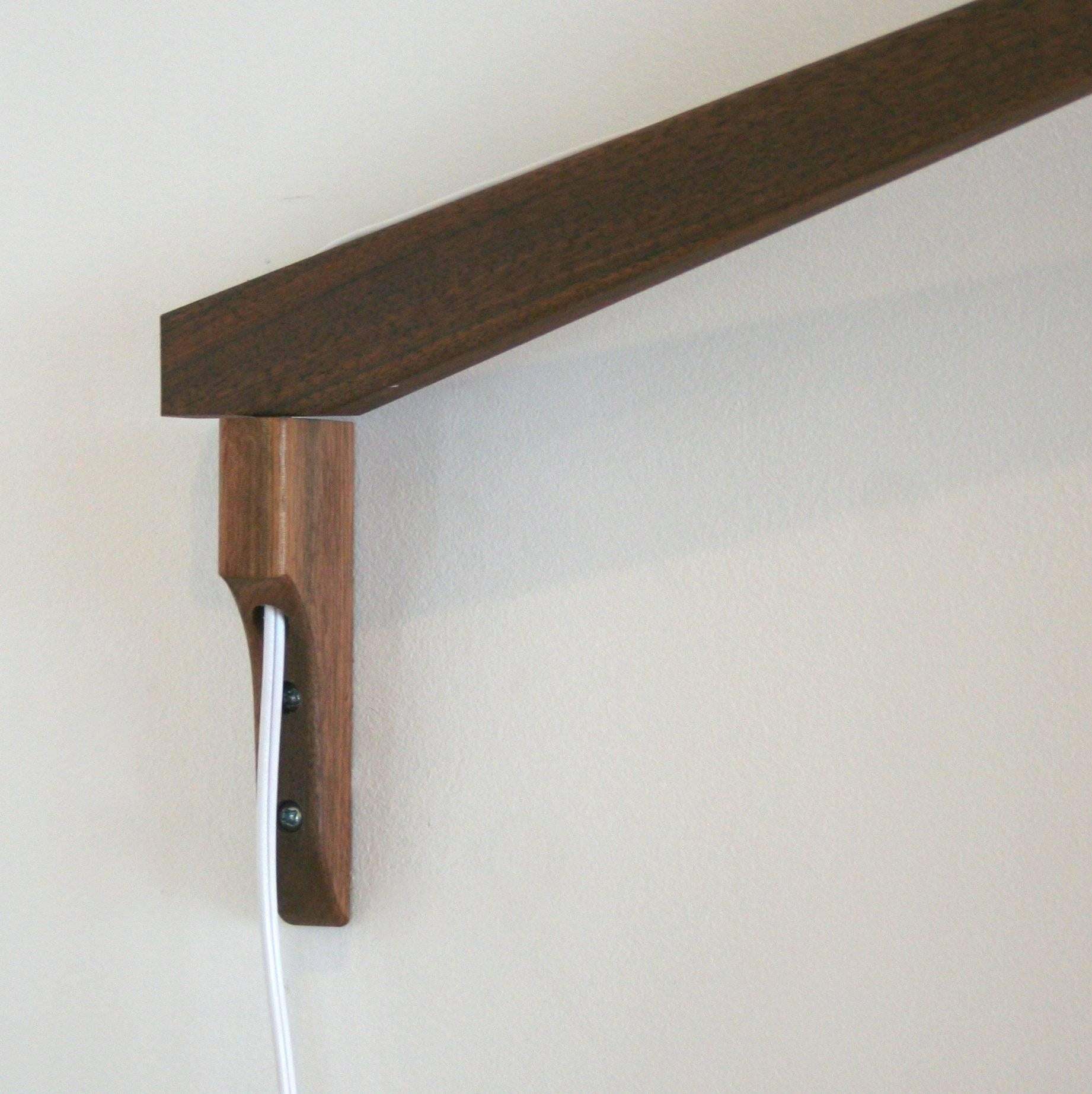 A swivelling wall mount with a full 180 degree range of motion. The pendant is a unique fibreglass and cord shade accented in a walnut frame. Measures 80