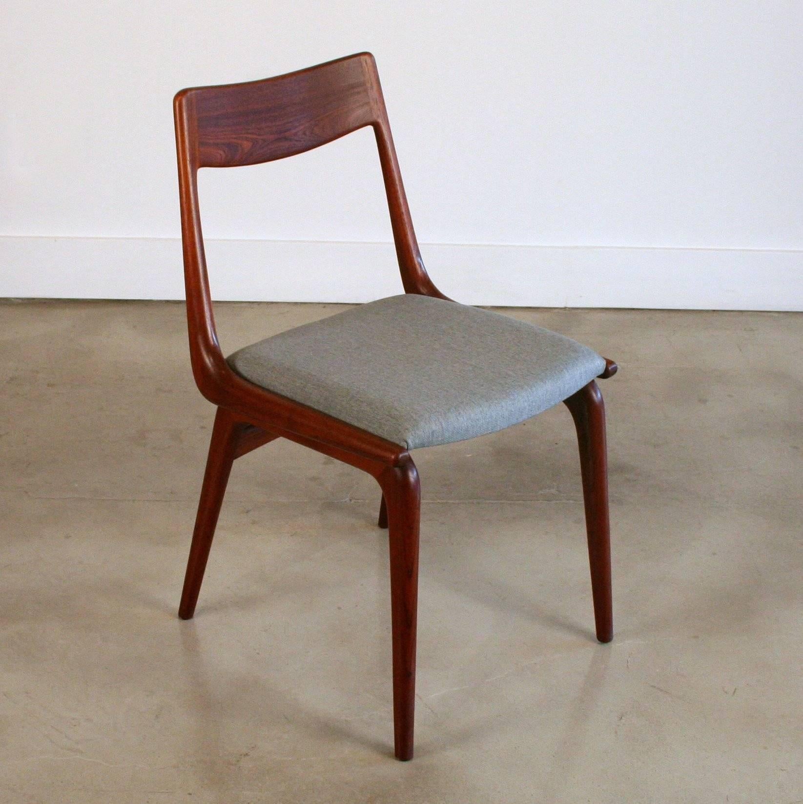 The forever popular Mid-Century Danish modern "Boomerang" dining chair, crafted from solid teak and newly re-covered in a light grey fabric. 12 available, sold individually. Made in Denmark, circa 1950s.