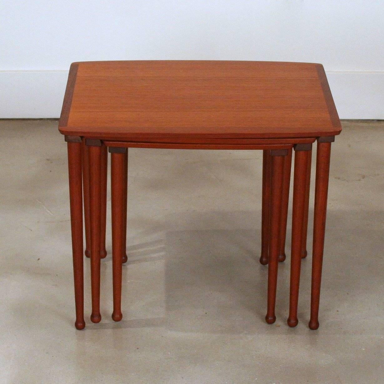 Vintage teak nesting tables with beautiful leg detailing and wonderful design means that they nest perfectly. Features inset finger pulls underneath each table. Made in Denmark.