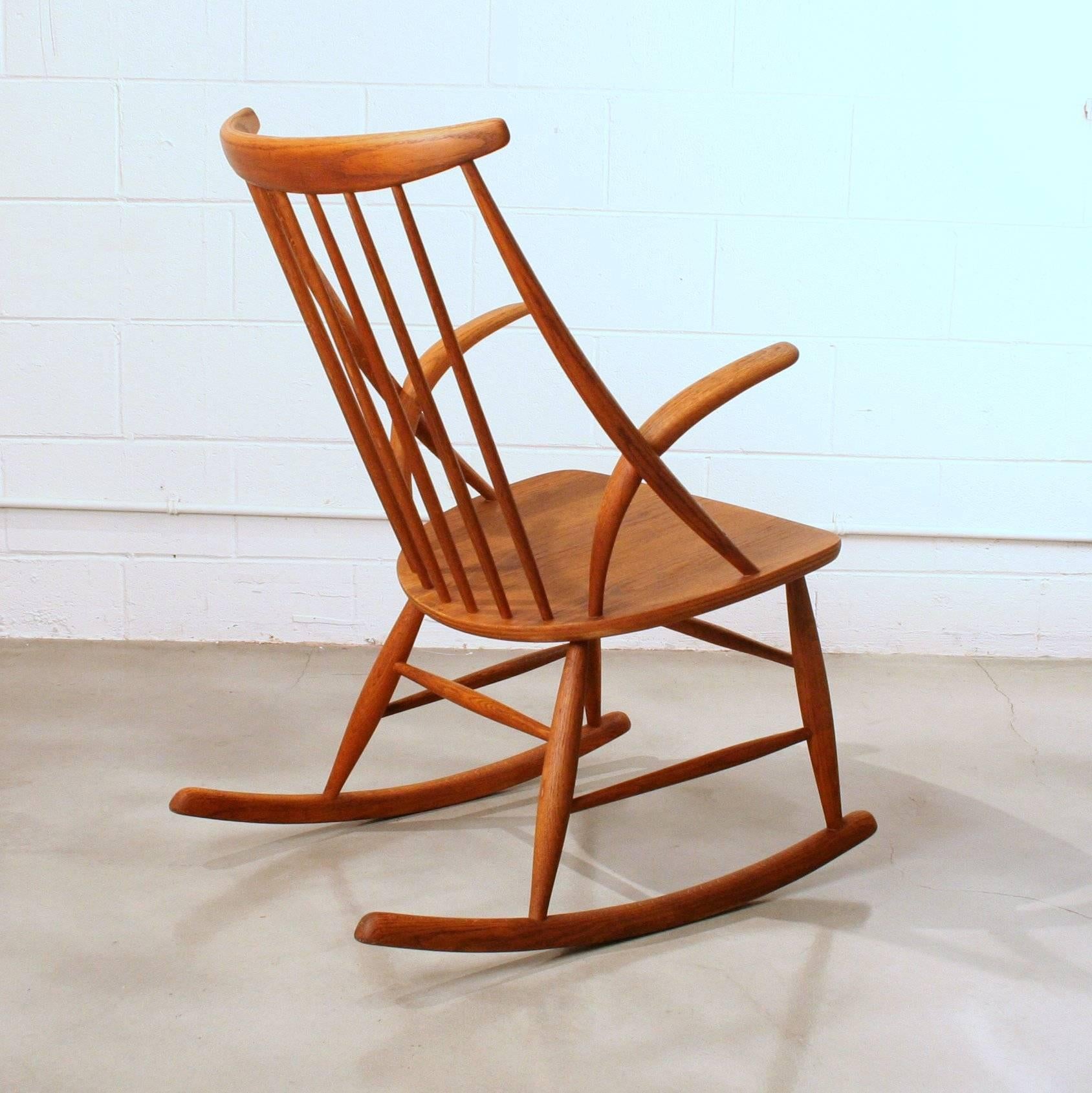 Vintage oak rocking chair featuring wonderful lines and beautiful graining throughout. This would be a fantastic addition to any Mid-Century inspired space. Made in Denmark.