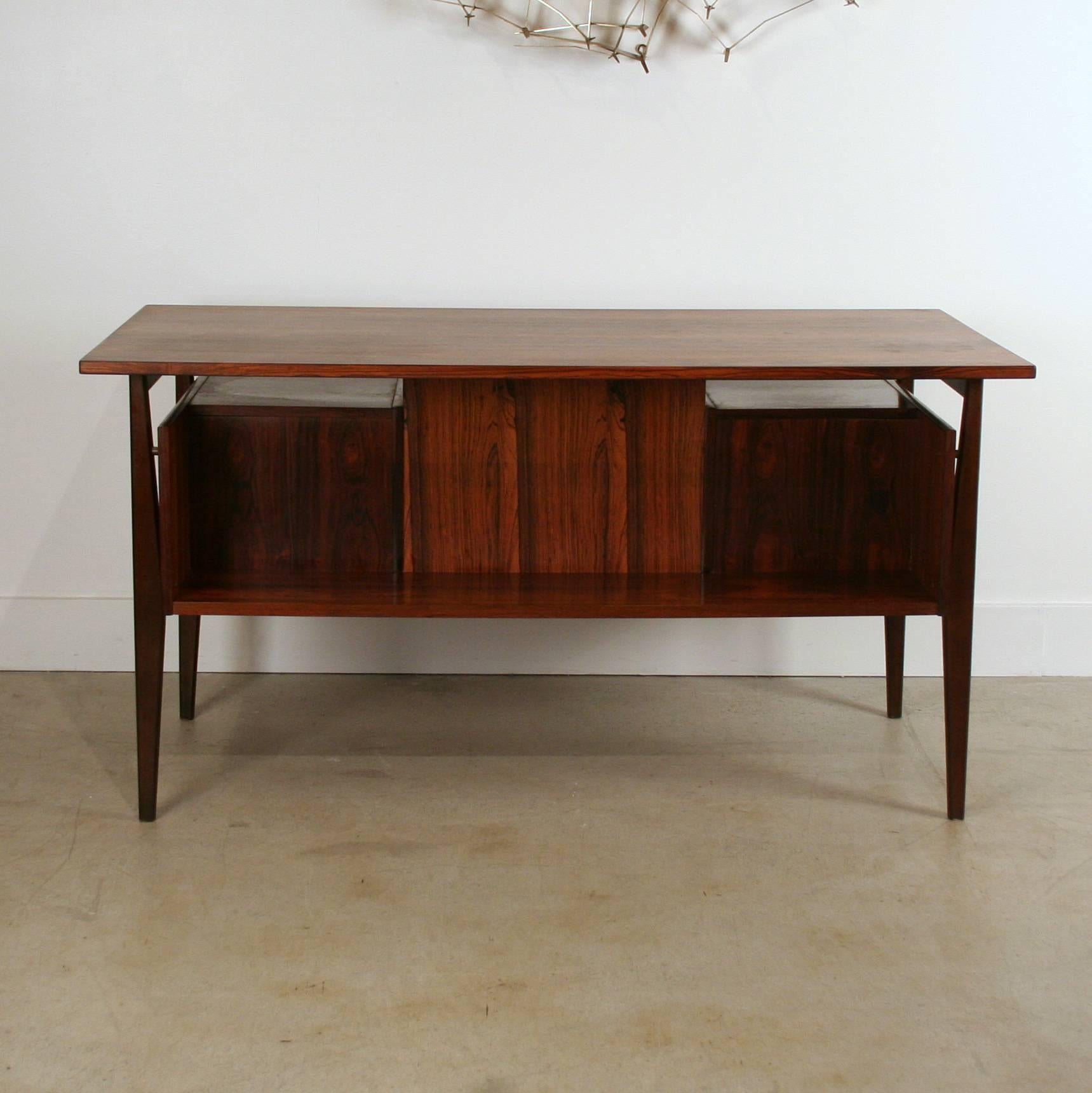 Absolutely stunning vintage rosewood desk. The rosewood graining on this piece is simply one of a kind. The desk features three drawers on each flank with inset finger pulls and dovetail joinery. The back of the desk also has a large shelf which