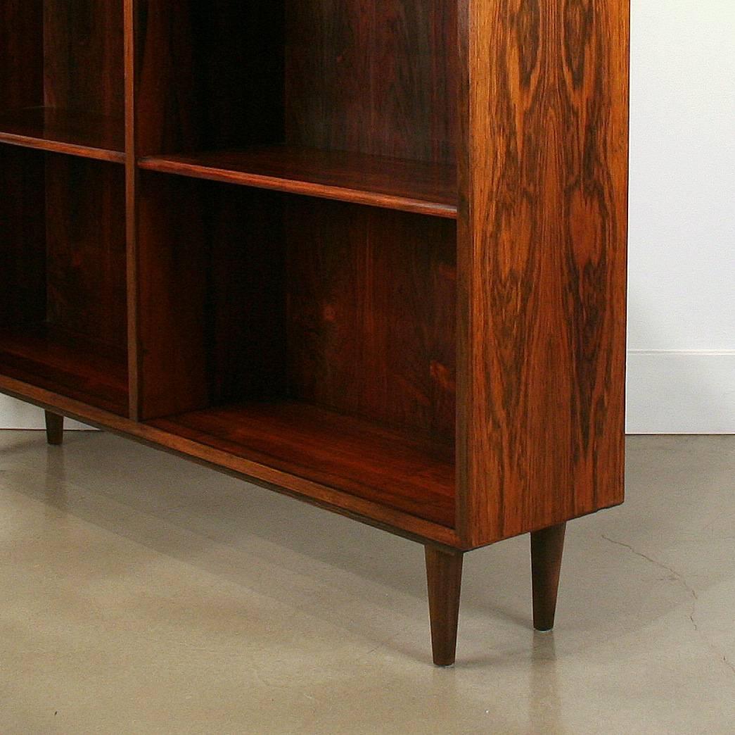 Beautiful vintage Danish rosewood bookcase with removable and adjustable shelves. Set on four conical legs. Wonderful rosewood graining throughout this piece. Made in Denmark.