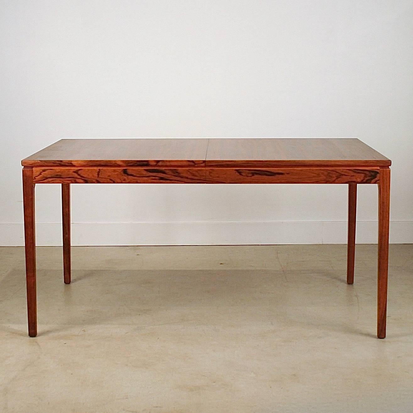 Stunning vintage Danish rosewood dining table with single leaf, stored separately. The rosewood graining throughout this piece is exceptional. Features one leaf at 16". Made in Denmark.