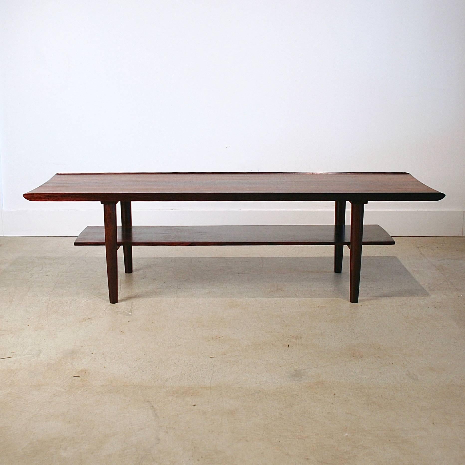 Exquisite vintage Danish rosewood coffee table with shelf. Features raised lip edge on tabletop and absolutely stunning rosewood graining throughout. Made in Denmark.