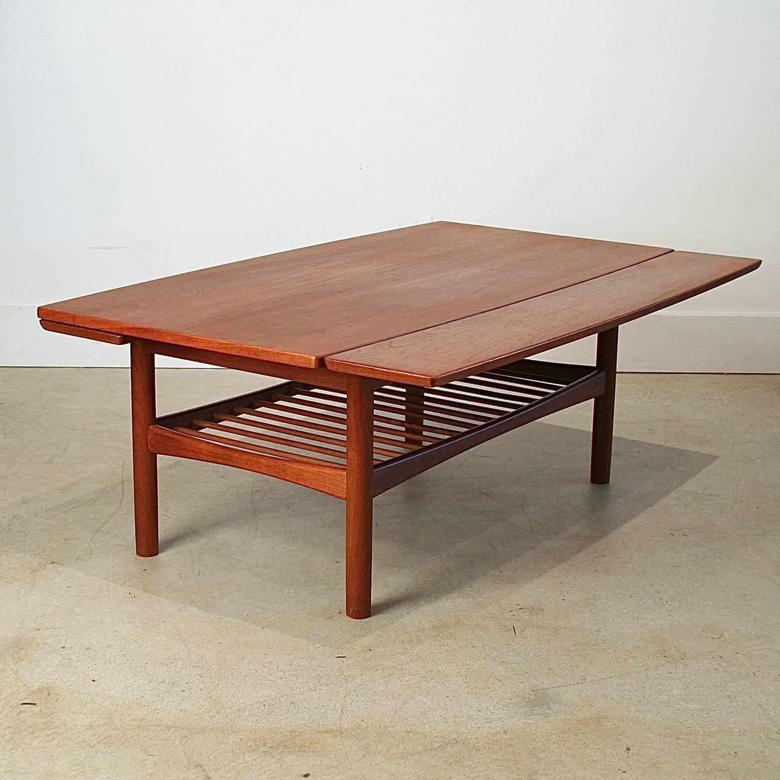 Beautiful vintage Danish teak coffee table with draw leaves and dowel shelf. Leaves are 6.5" each. Made in Denmark.
