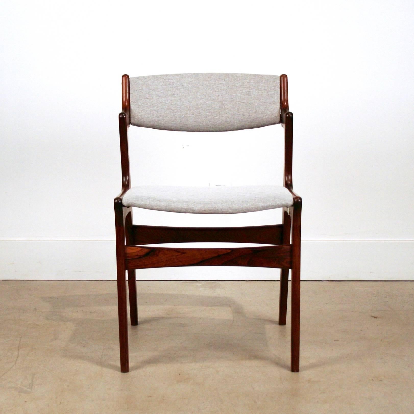 Mid-Century Brazilian rosewood dining chairs manufactured by Nova Manufacturing, Denmark. The chairs feature solid rosewood frames with half arms, rich dark grain and exposed finger joinery. Newly upholstered in light grey fabric. Fully restored and