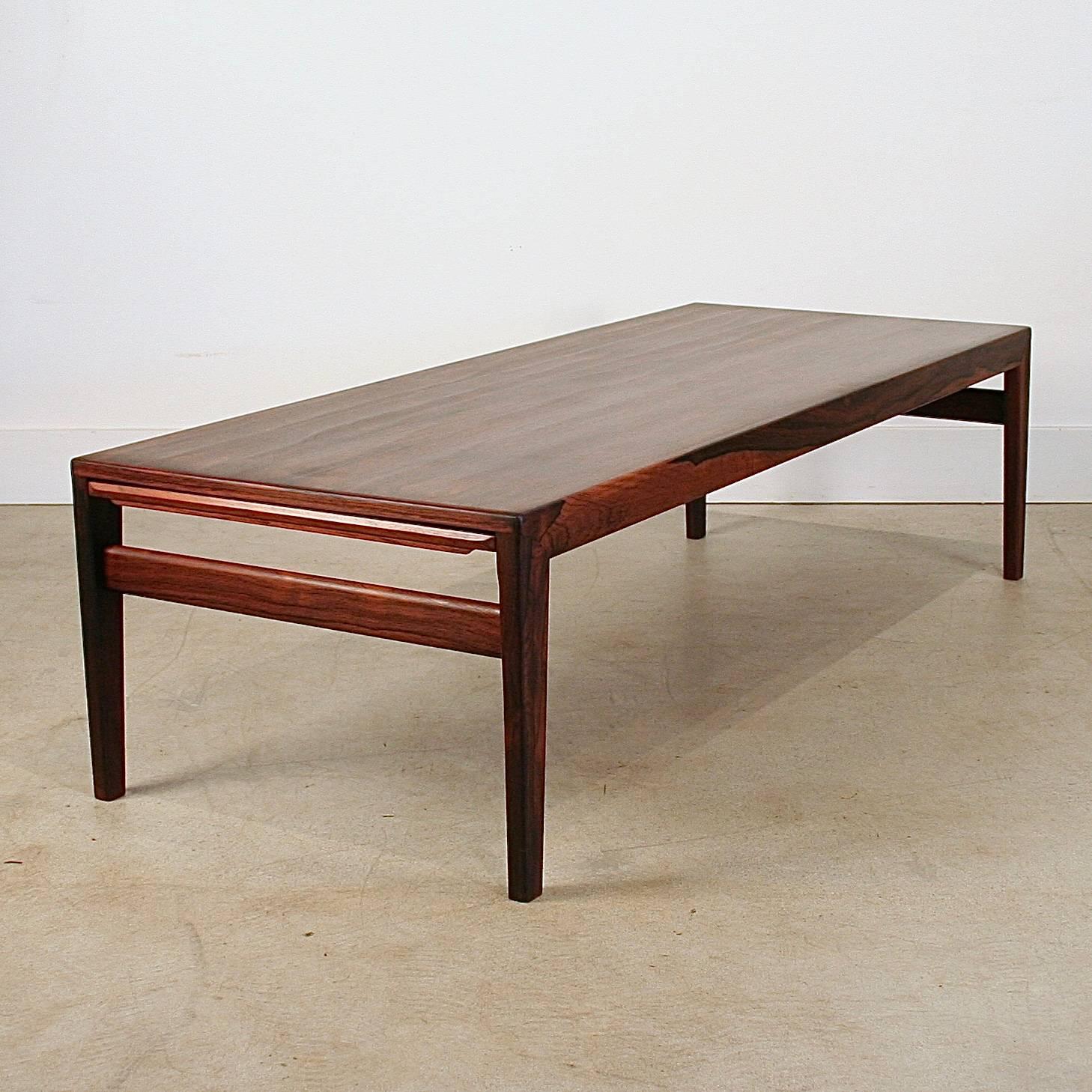 Absolutely stunning vintage Danish rosewood coffee table. Features two leaves on each end which slide out with the help of a wonderfully crafted finger pull. One leaf has the same beautiful graining as the tabletop and one is suitable for hot cups