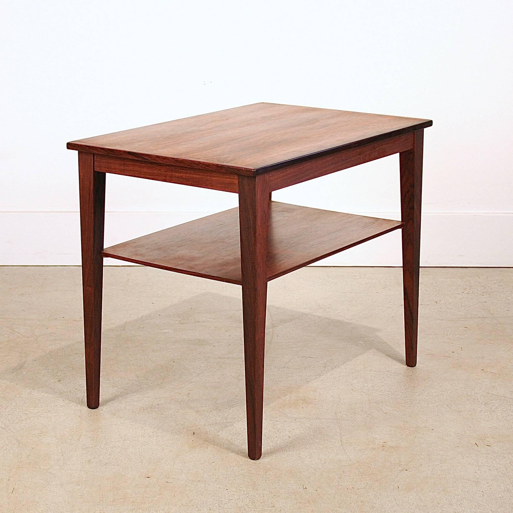 Vintage Danish rosewood side, accent or end table with shelf and beautiful rosewood graining throughout. Pair available, priced and sold separately. Made in Denmark.
 