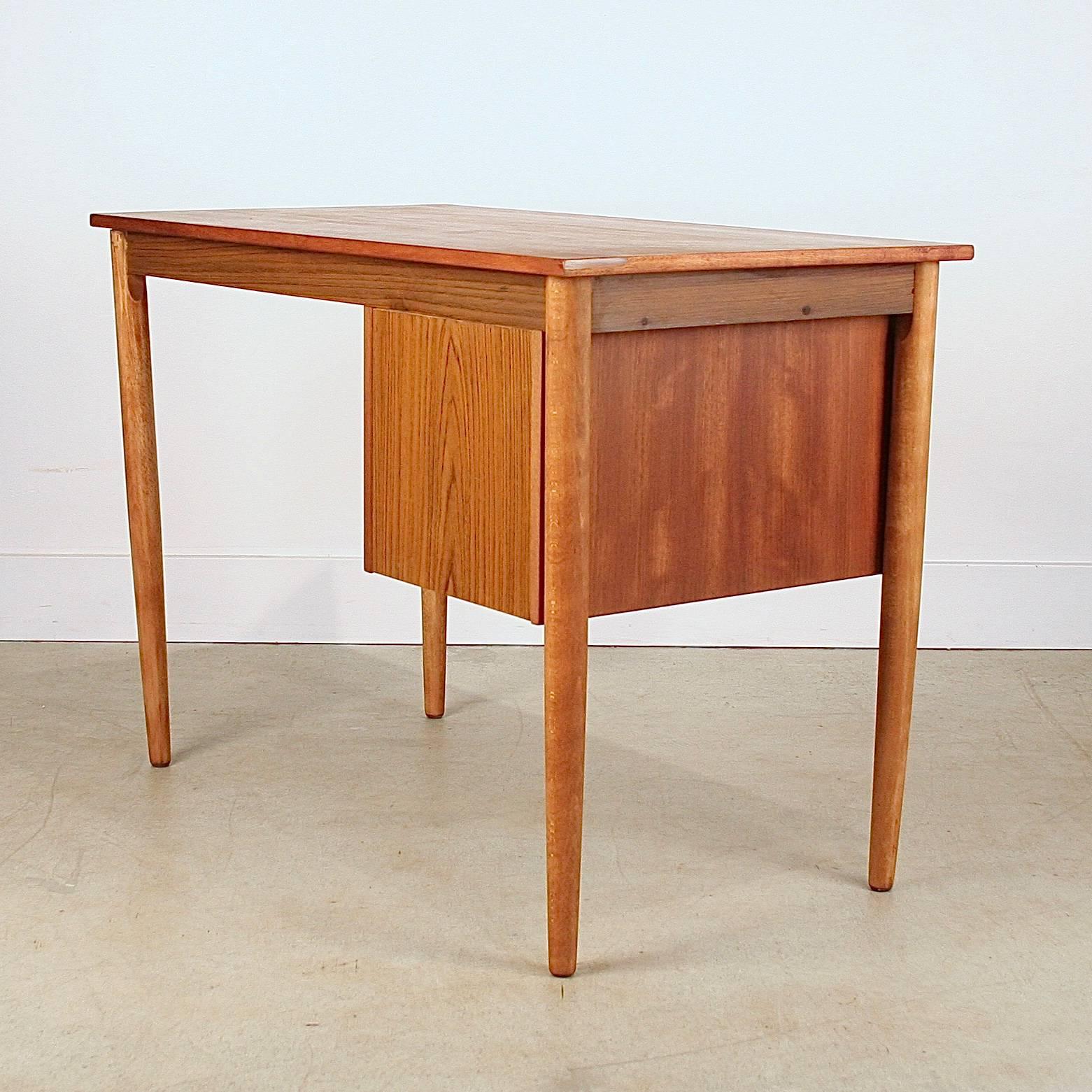 Vintage Danish teak writing desk featuring three drawers with lip pulls. Made in Denmark.
 