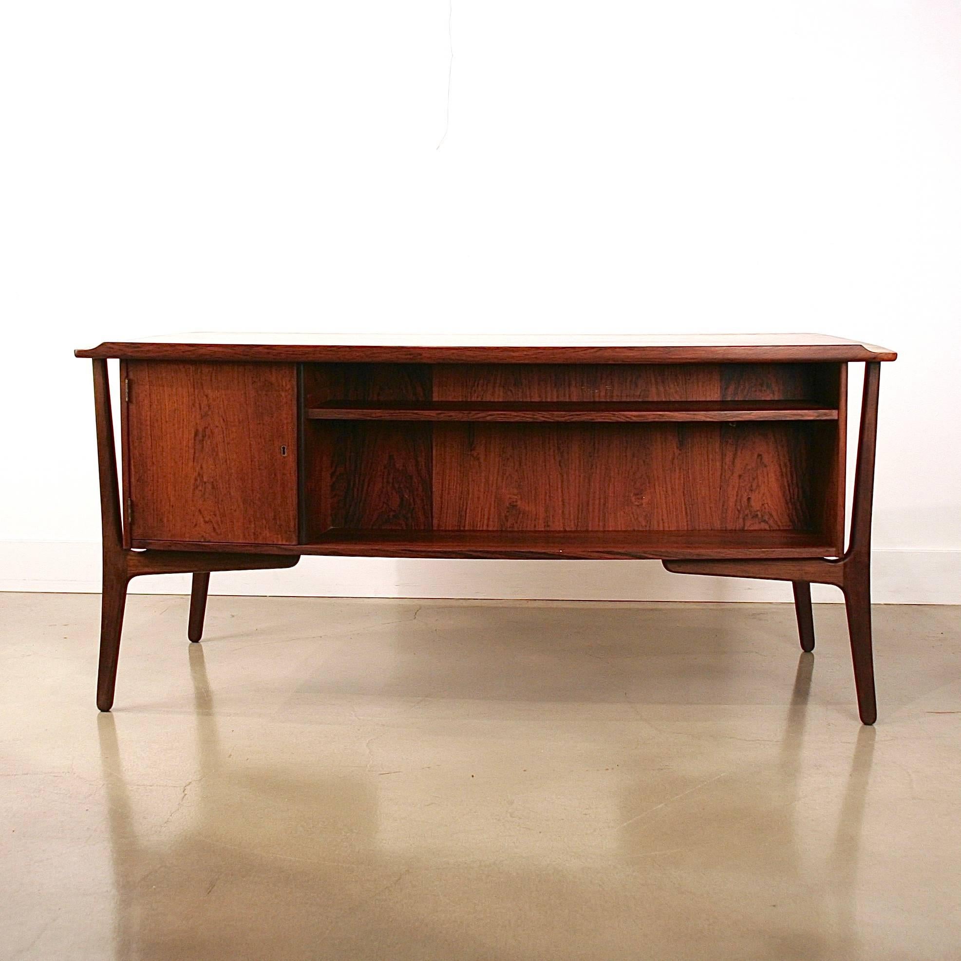 Absolutely stunning vintage Danish rosewood desk by Danish designer Svend Madsen. The desk features 'floating' banks with four drawers in each with wonderfully detailed finger pulls. The desktop has a beautiful lip detail on the back edge and