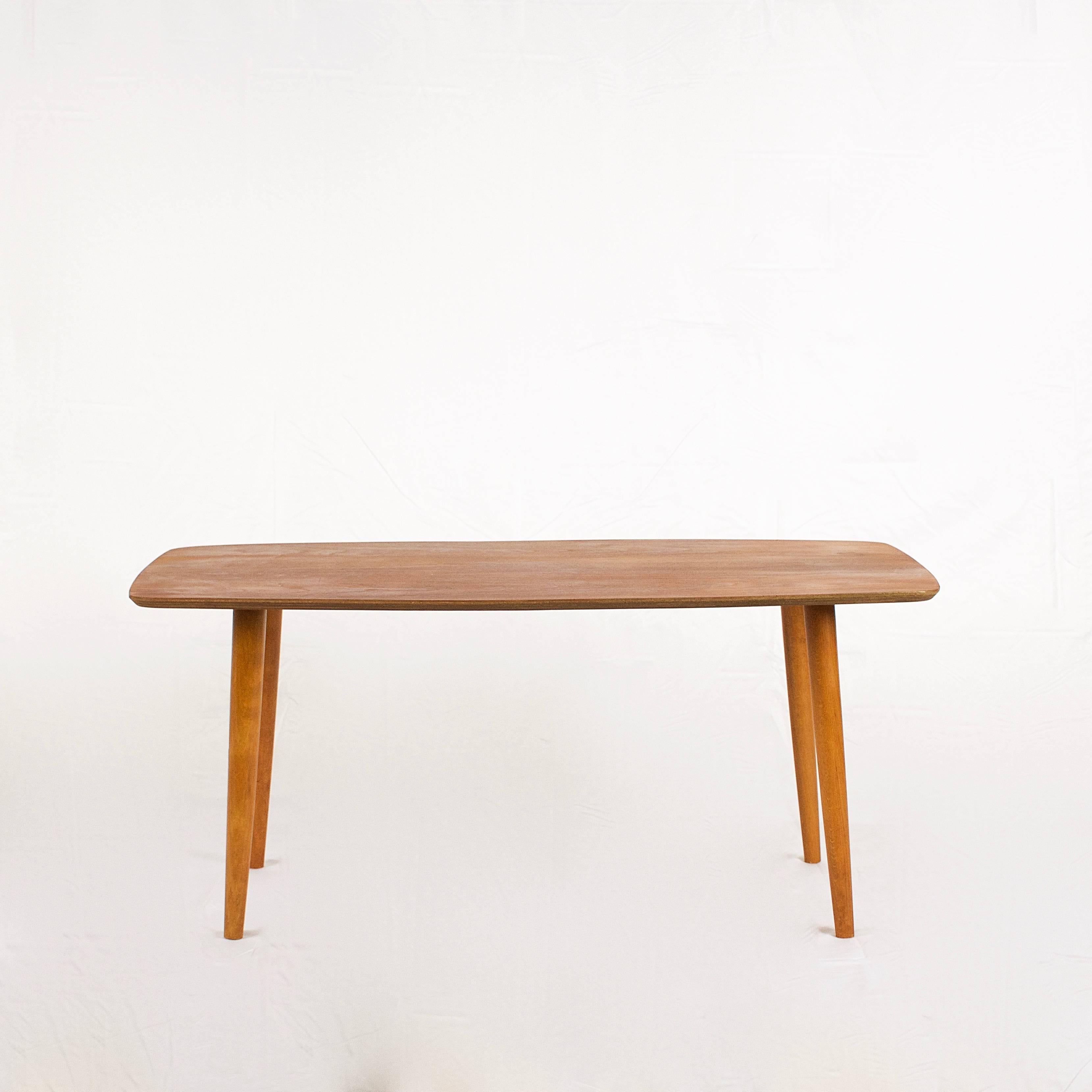 Gorgeous vintage Danish teak coffee table. Tabletop features beautiful graining throughout and is set on four tall conical legs. Made in Denmark.
 