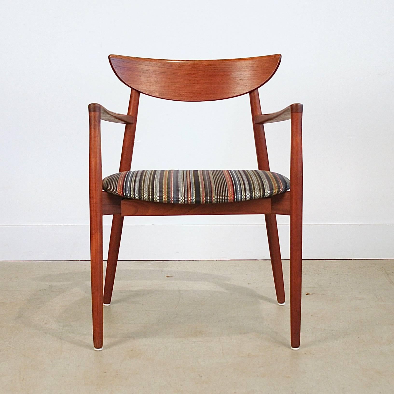Beautiful vintage teak arm chair with half moon back rest and fin. The teak Carver chair designed by Harry Ostergaard for Randers manufacturing, Denmark. Newly reupholstered. Made in Denmark. 