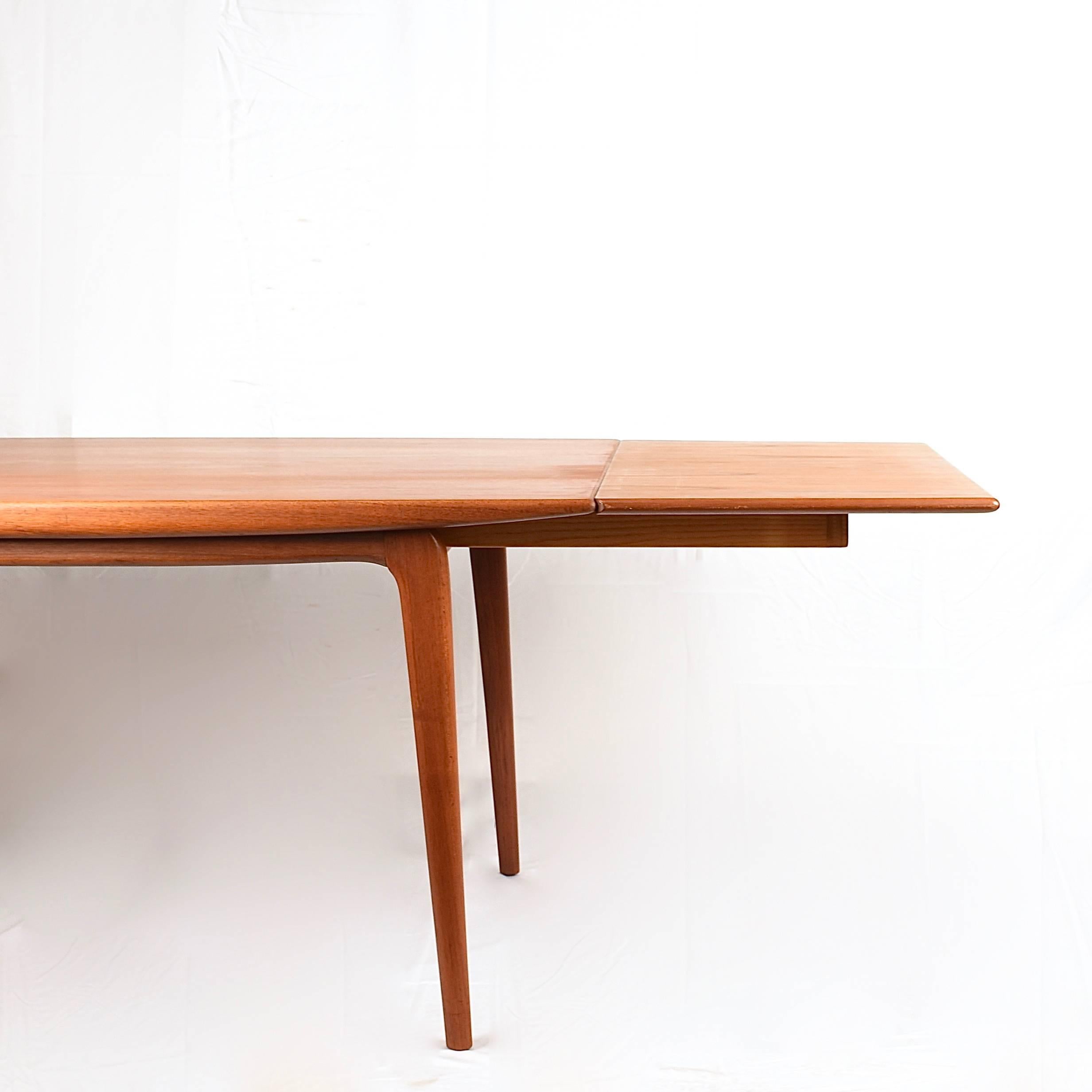 Beautiful vintage Danish Erik Christiensen teak boomerang table with leaves. Exquisite tapered tabletop set on wonderfully crafted 'boomerang' style legs. Made in Denmark.
 