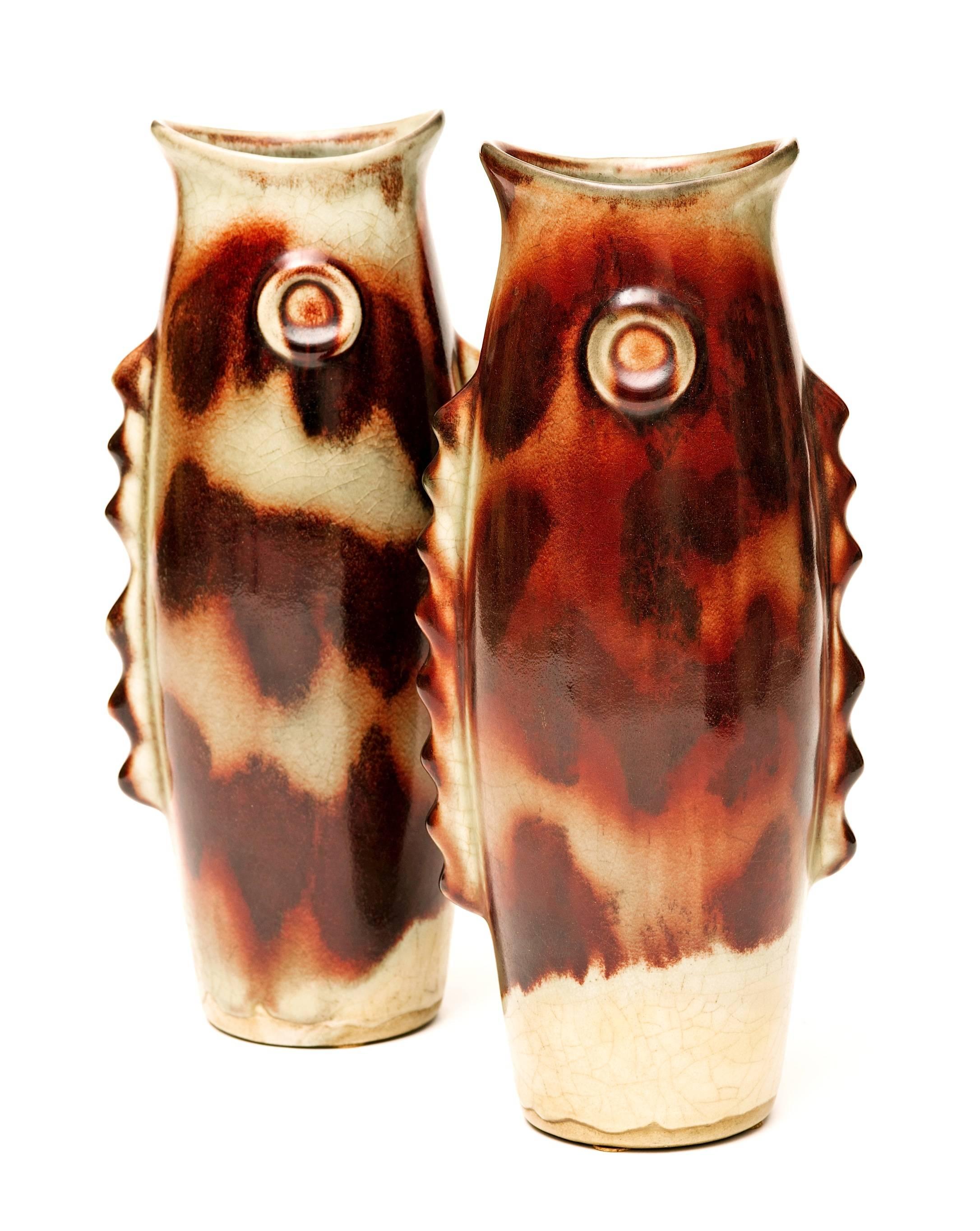 A stunning pair of Sculptural Asian Art Deco ceramic fish vases, circa 1930s with rich oxblood colors and a crackle glaze. Each hand-painted vase has slight variations and are painted on both sides. These are truly unique both as vases or