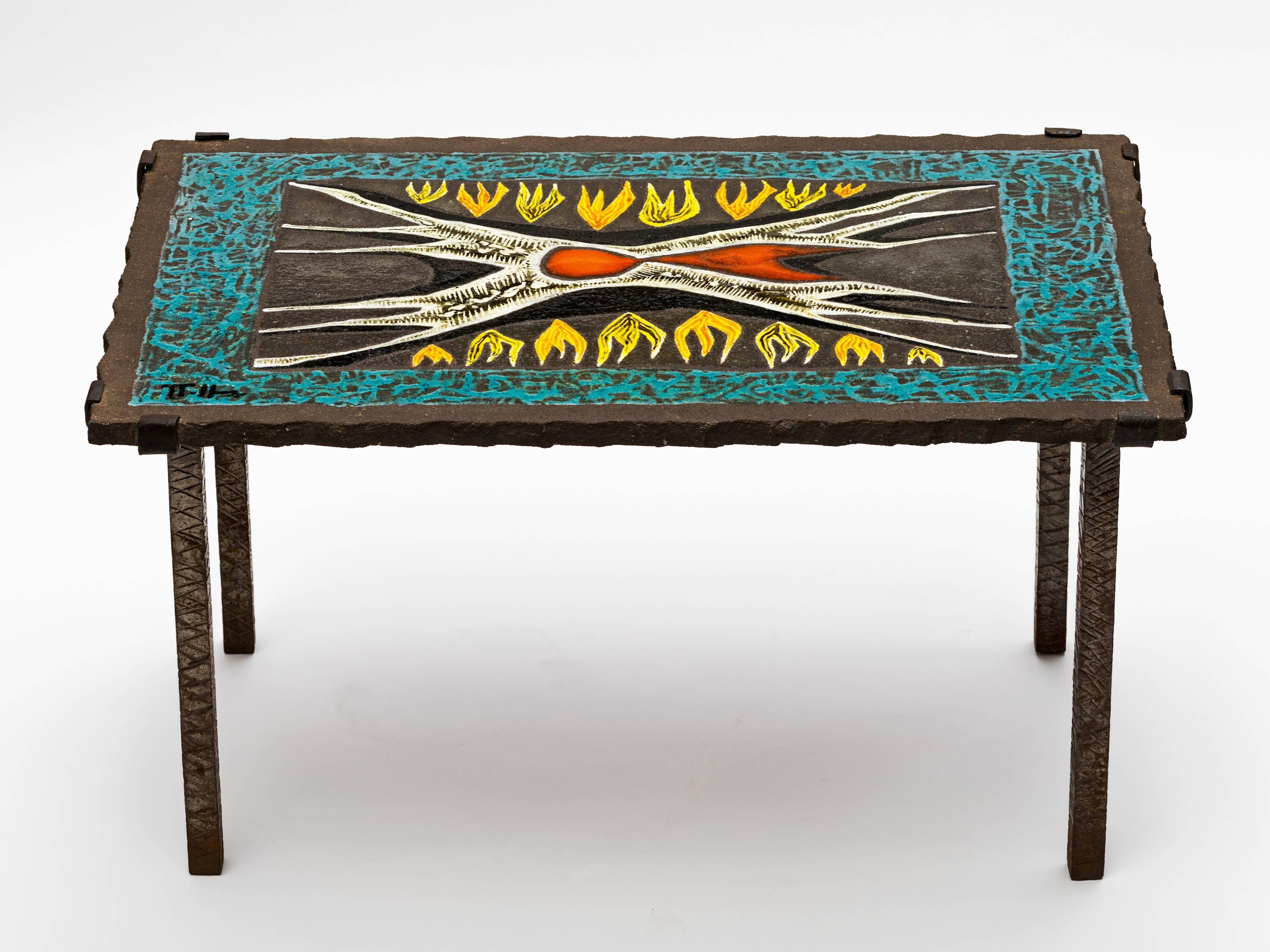 Superb lava stone enameled coffee or end table by French Artist Jean Jaffeux, circa 1950s with hand-wrought etched iron legs. This fabulous flame design is reminiscent of a Jean Lurcat or Marc St. Saens Tapestry. Signed lower left.