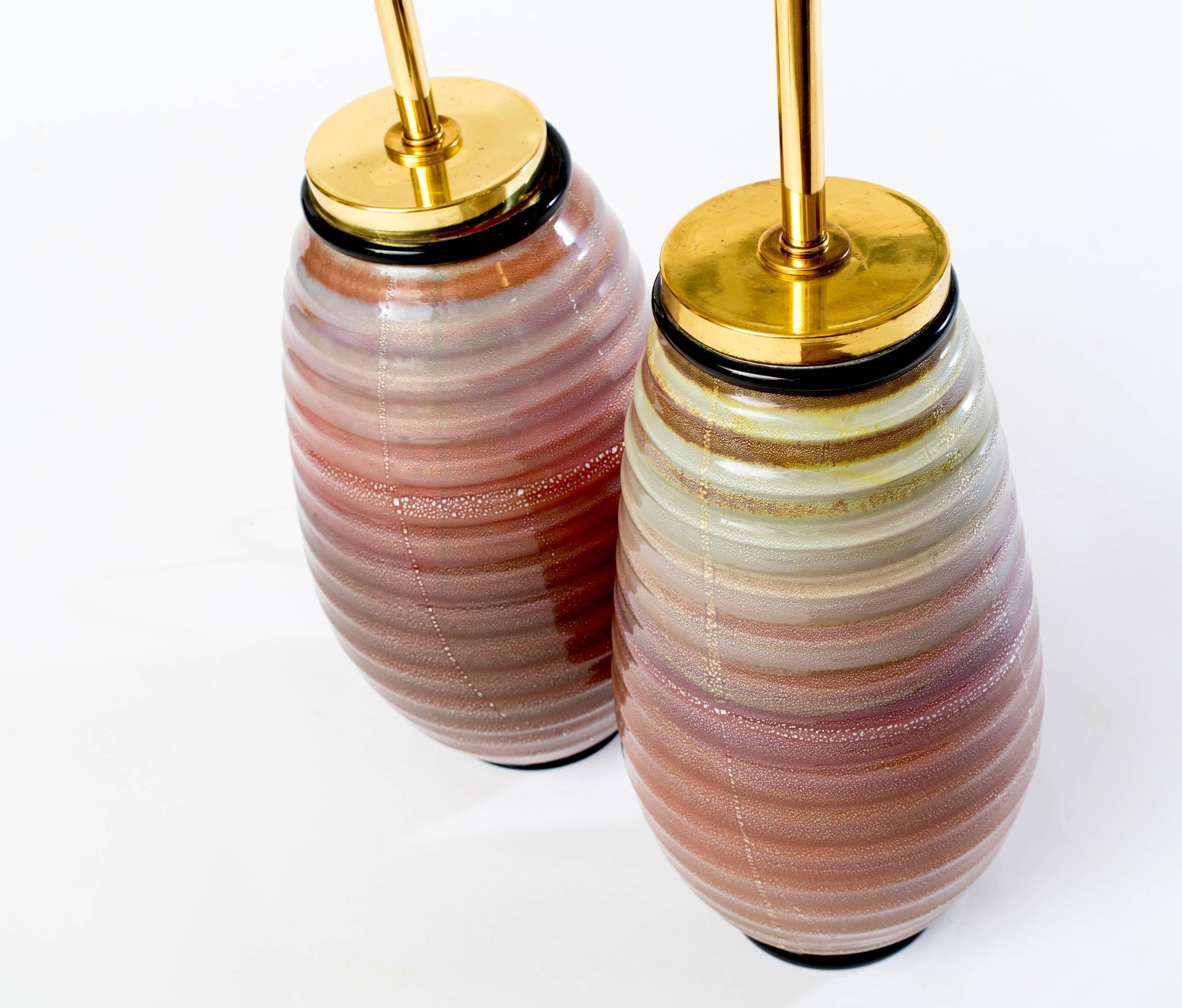 Stunning and rare pair of large Seguso Murano table lamps, circa late 1940s-early 1950s. Beautiful cased glass with mica and a black lip wrap to the top and base. Colors graduate from champagne to dark cinnabar with lines of mica and each lamp is