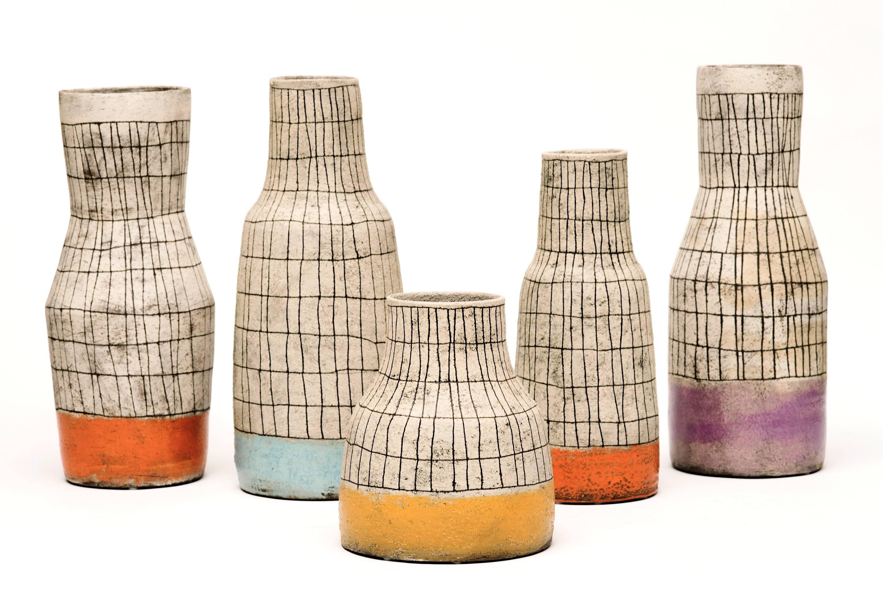 Stunning contemporary set of five sculptural vases with hand-painted lines and glazed colored bands consisting of yellow, orange, blue and lavender by U.S. artist. A perfect accent with 20th Century design.
Sizes vary from the shortest at 9.25
