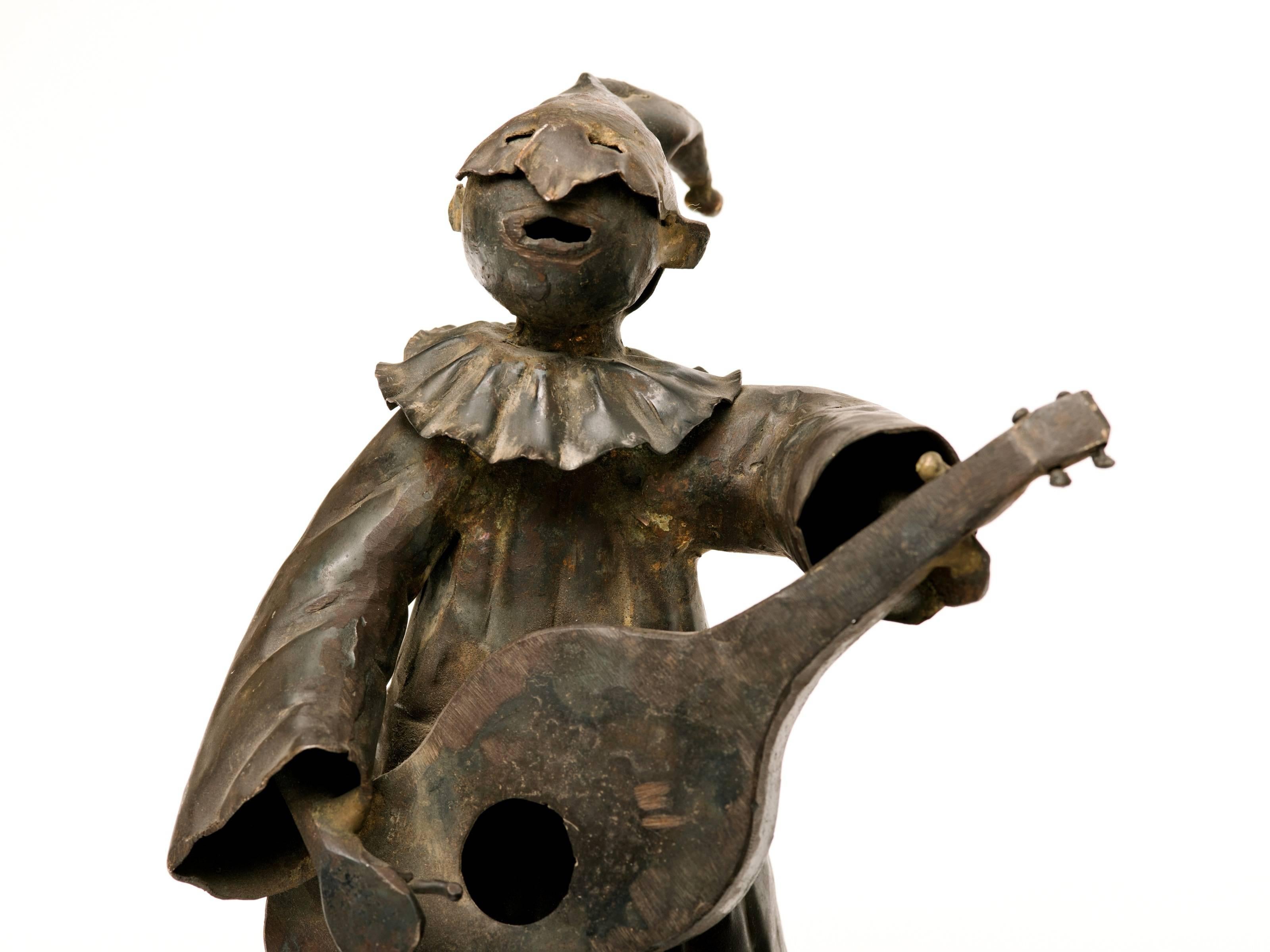 Rare, Fun and Whimsical is this pair of Commedia dell'arte metal sculptures from Italy circa 1950's. To the eye, these are quite unique and commanding in presence. One is a masked guitar player while the other is a performer.  
Commedia a form of