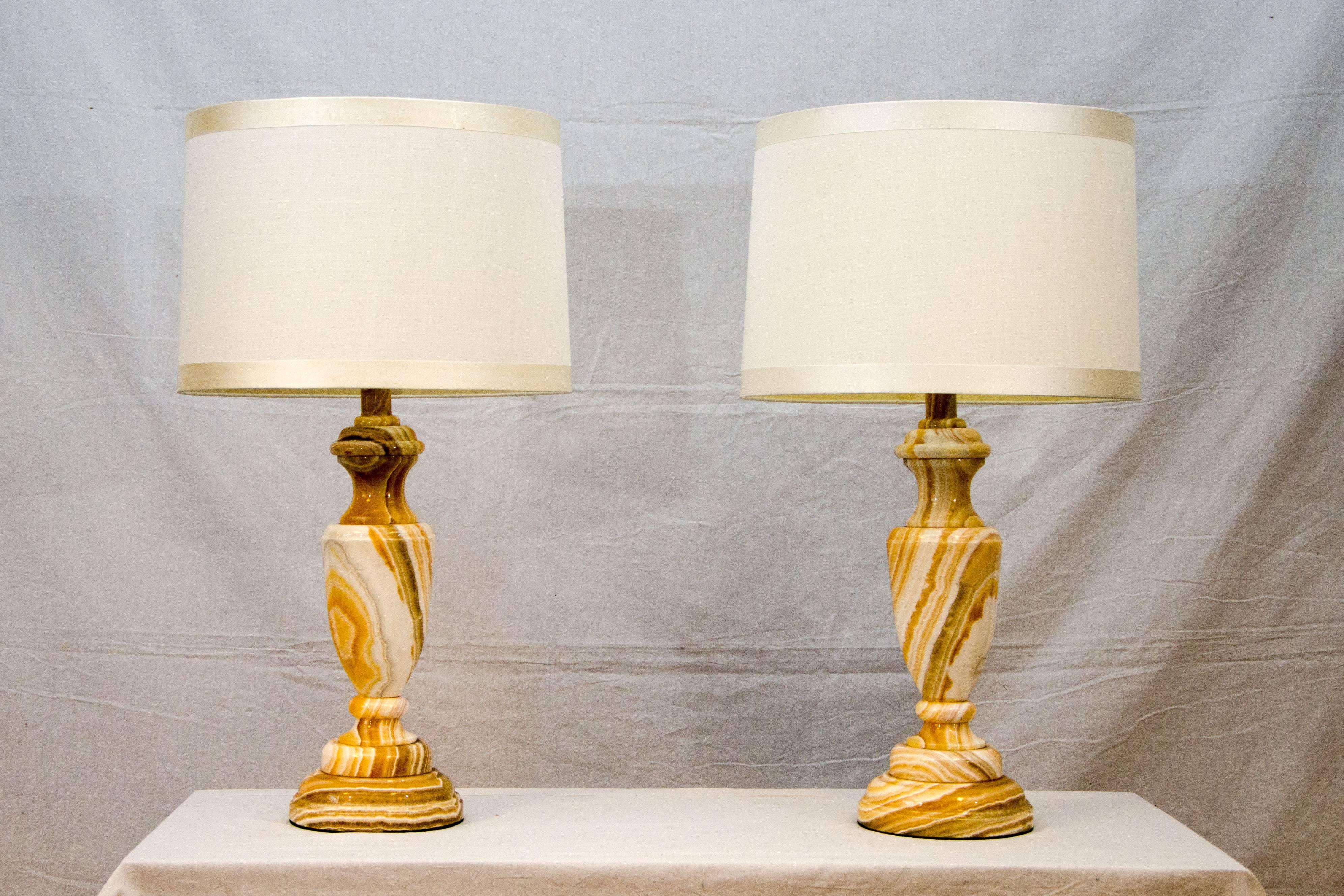 Nice pair of onyx table lamps in white and various shades of tan as well as grey. The on/off knobs resembles a key. The onyx bases are 19" high. They are heavy and very stable.