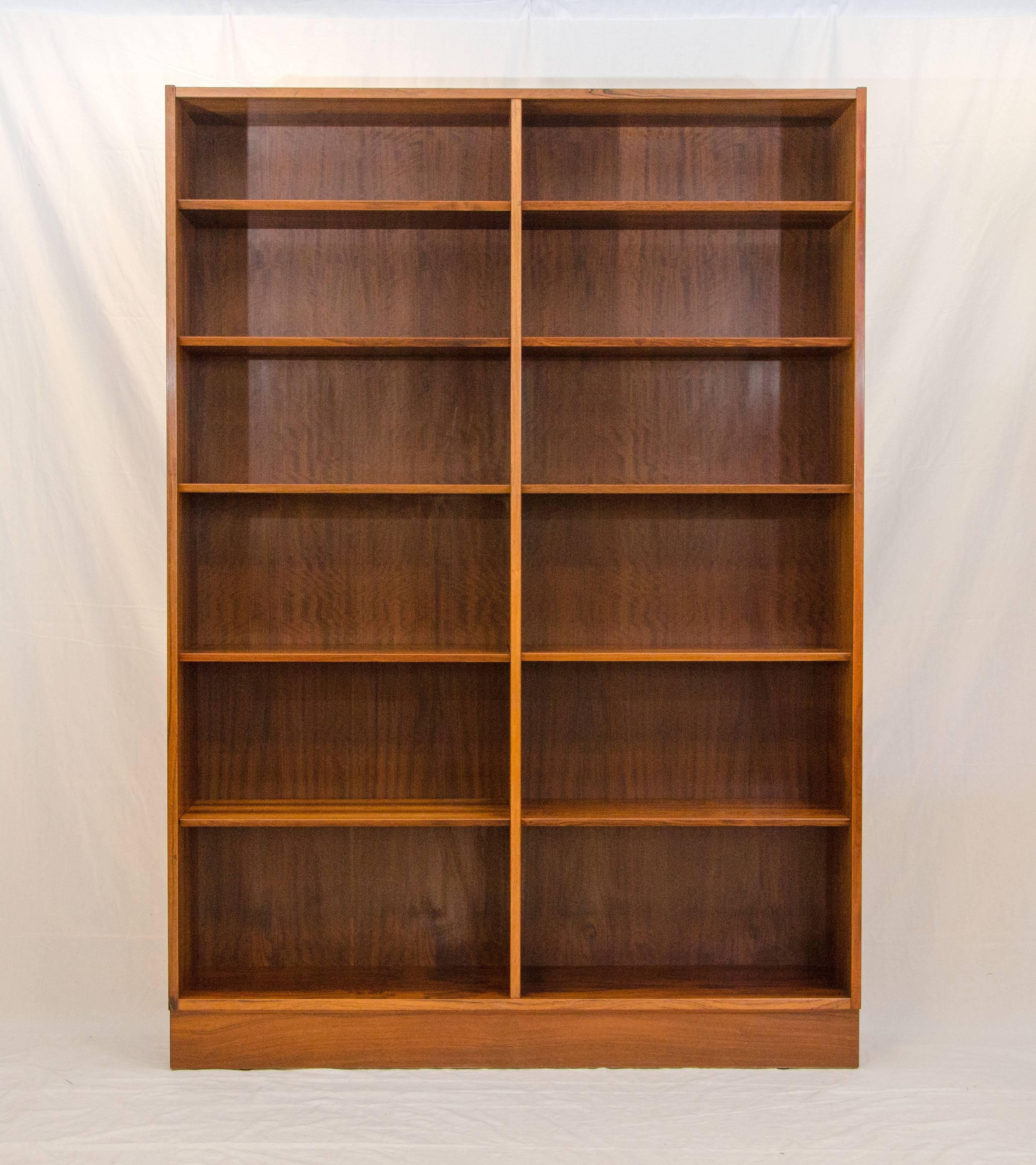 Spacious Brazilian rosewood bookcase with two stationary shelves and eight adjustable ones. The front shelf edges are angled rather than a typical flat front edge. There is a small wire bracket that the shelves slide onto. The rosewood grain