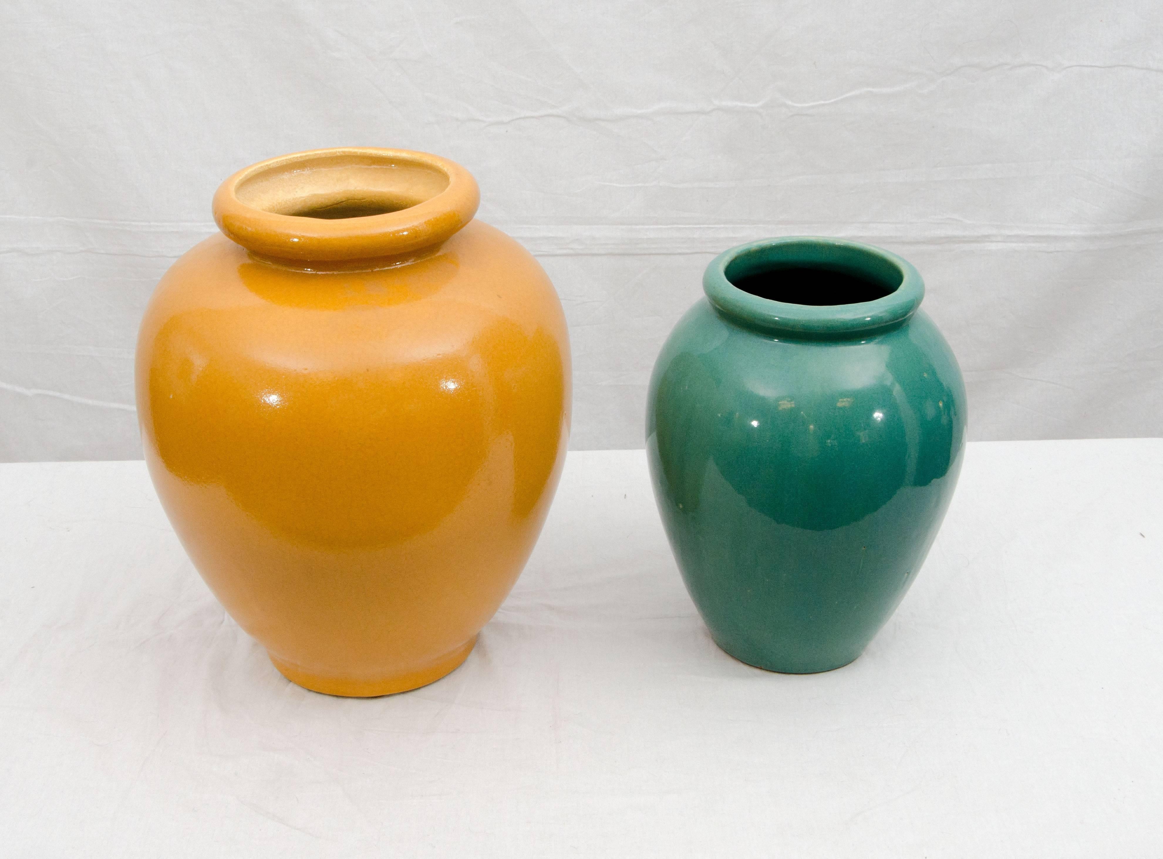 Pair of garden pots or urns or as interior accent floor vases. The taller yellow urn is unmarked and has a hole in the base. The shorter green one has "McCoy" markings.
Dimensions are:
Yellow pot 15 1/2" tall, 12" diameter at