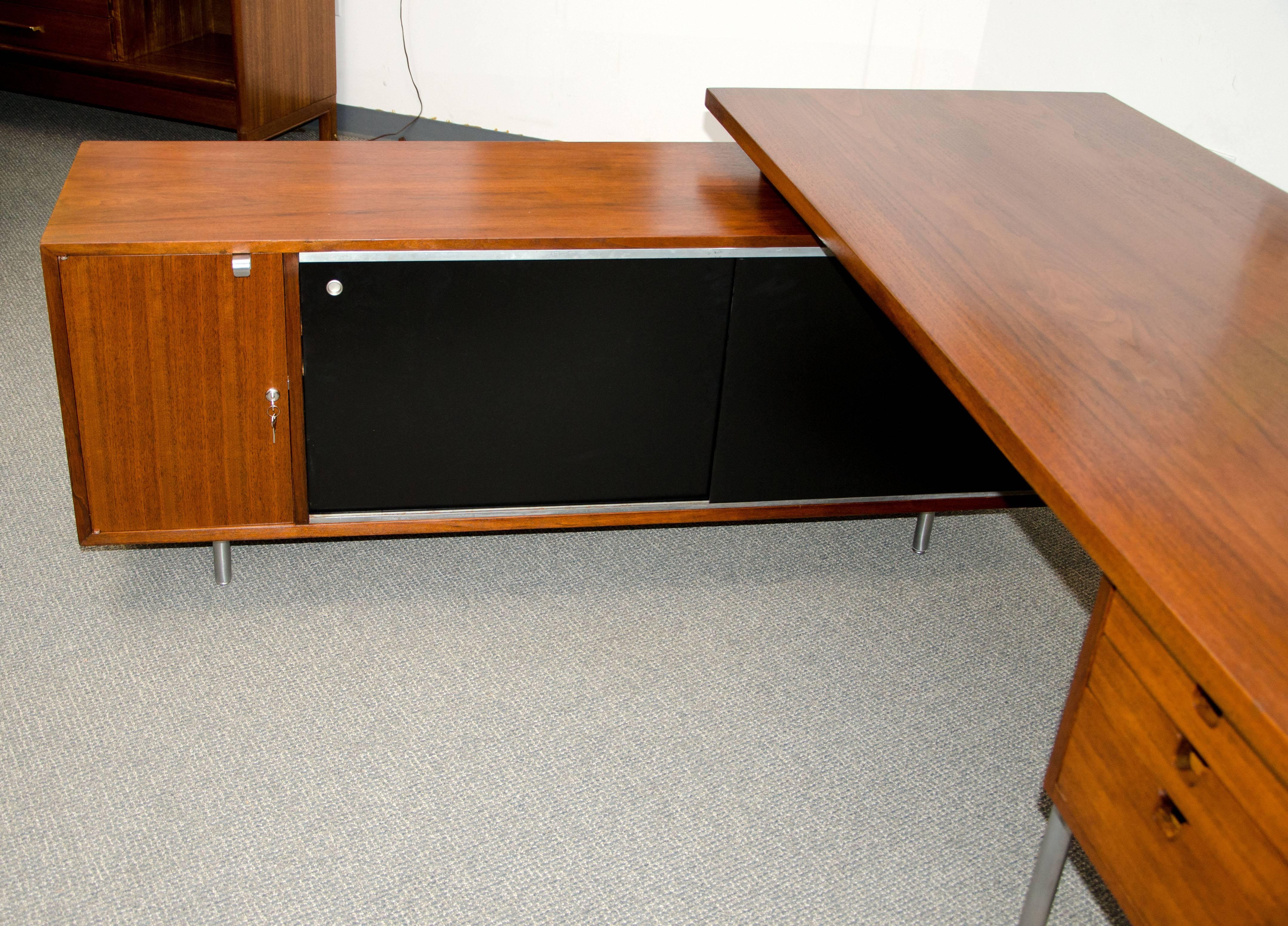 Very nice Mid-Century walnut executive desk with a credenza return. It can be placed in the center of a room with access to all sides. The desk is attached to the credenza in an 