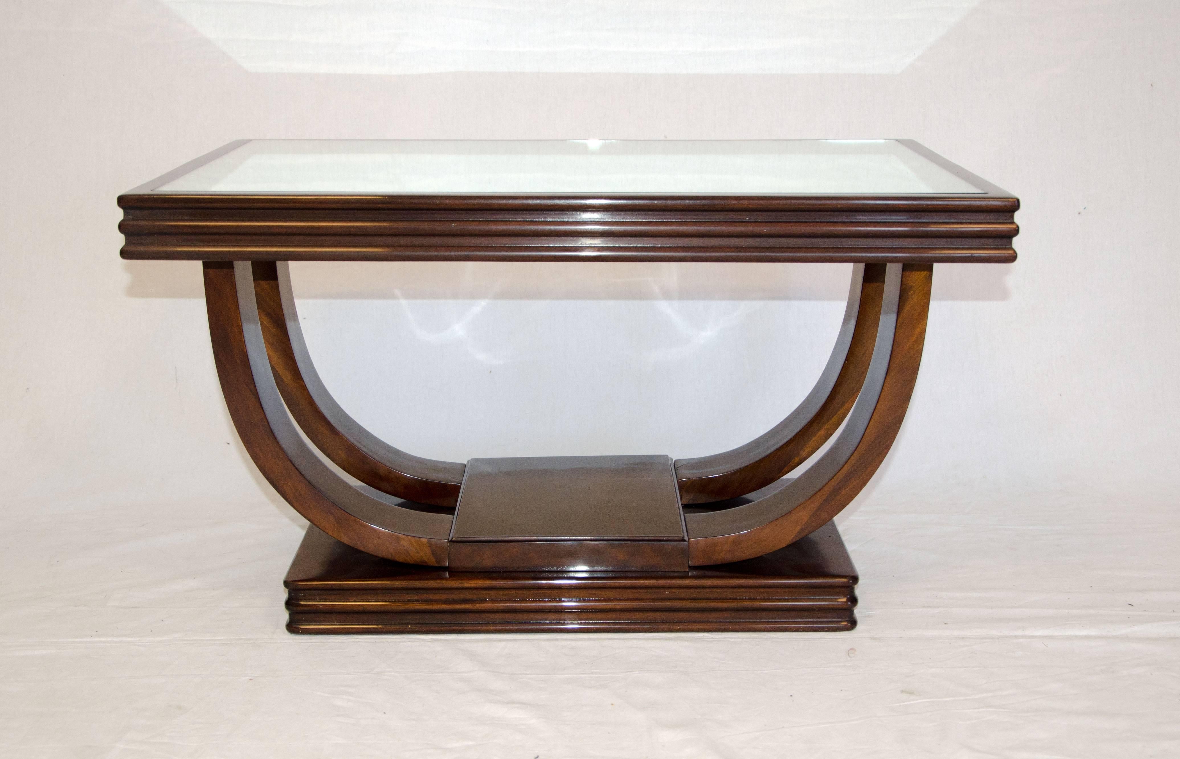 This smaller size cocktail table has a very nice Art Deco design. Four curved pieces separate the base and top. The top is fitted with a mirrored glass insert. Table could be used as an accent table between a pair of Art Deco lounge chairs as well.