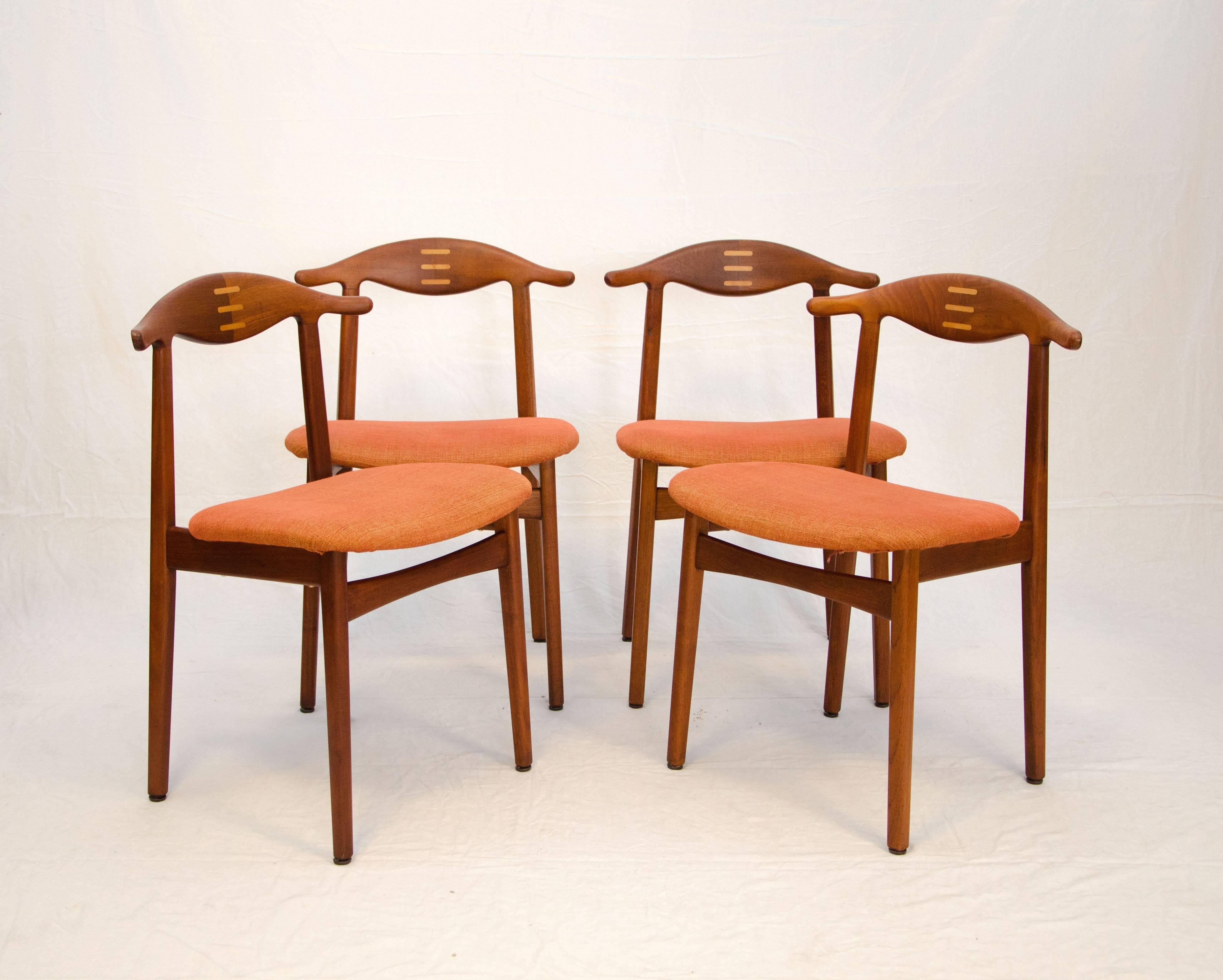 Rare and unusual set of four cowhorn style Danish teak dining chairs with inlaid beech cross bars on each back. The seats are nice and wide for comfort. They have had this fabric installed probably over the original so your choice of upholstery is