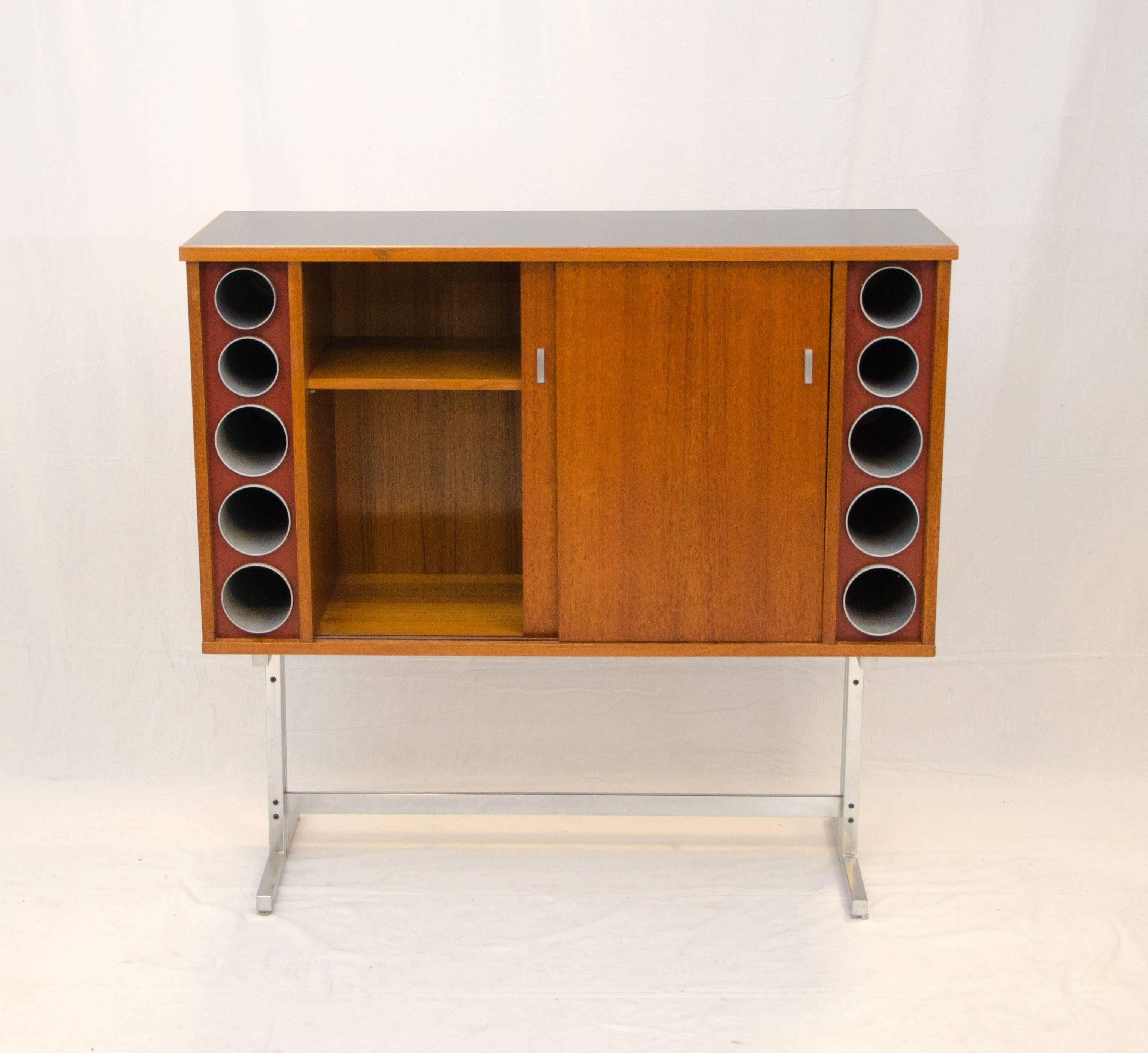 An unusual bar or cocktail cabinet with lots of storage for bottles and glassware and a Formica mixing surface, bottle storage is also available in tubular spaces on both sides of sliding doors. Each set has two 3 1/4" diameter tubes and three