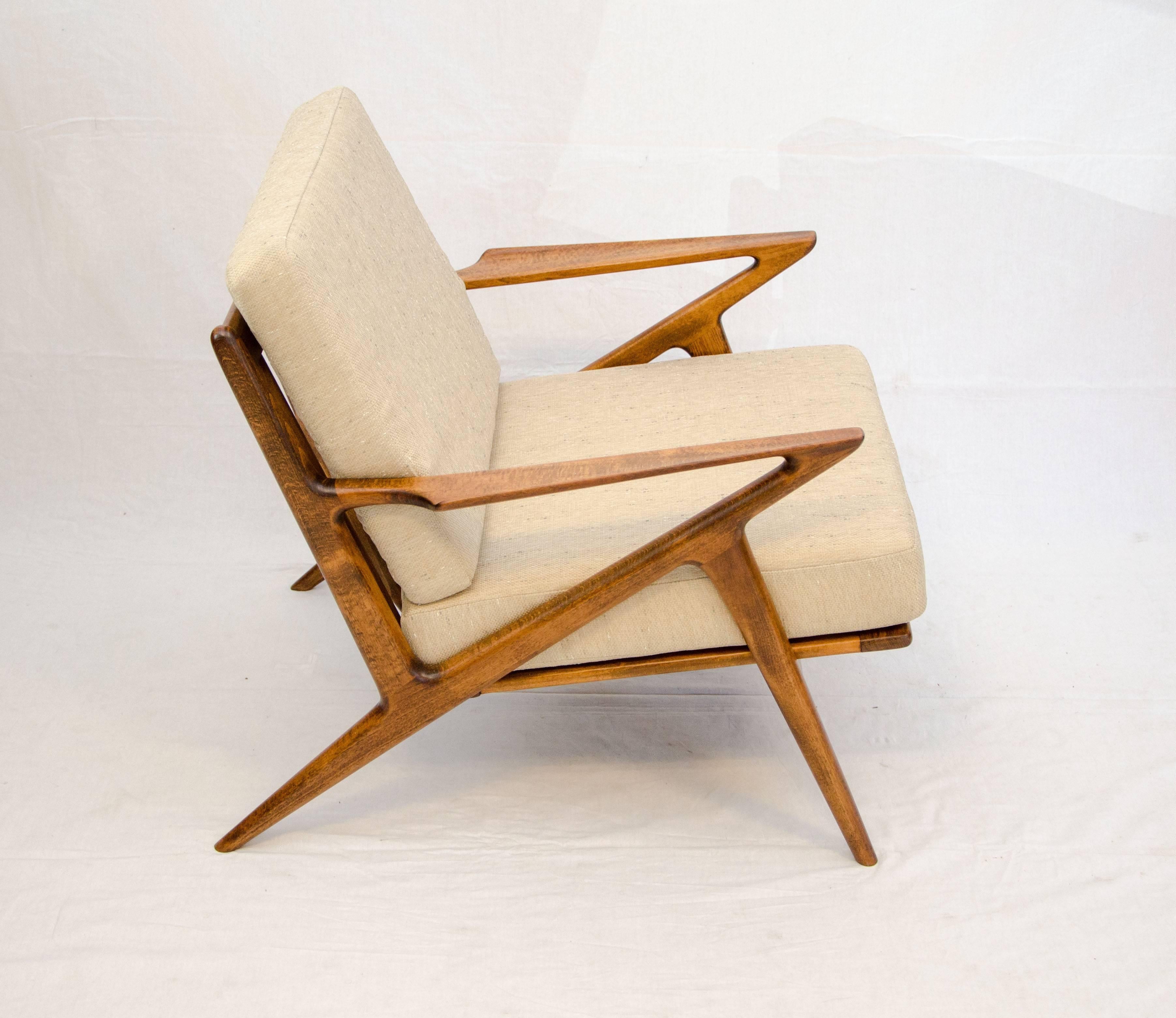 This popular Z lounge chair is always a favorite. This is birch with a teak finish and displays nice wood grain patterns on the arms as well as an upturned edge. It has a great looking angular design.