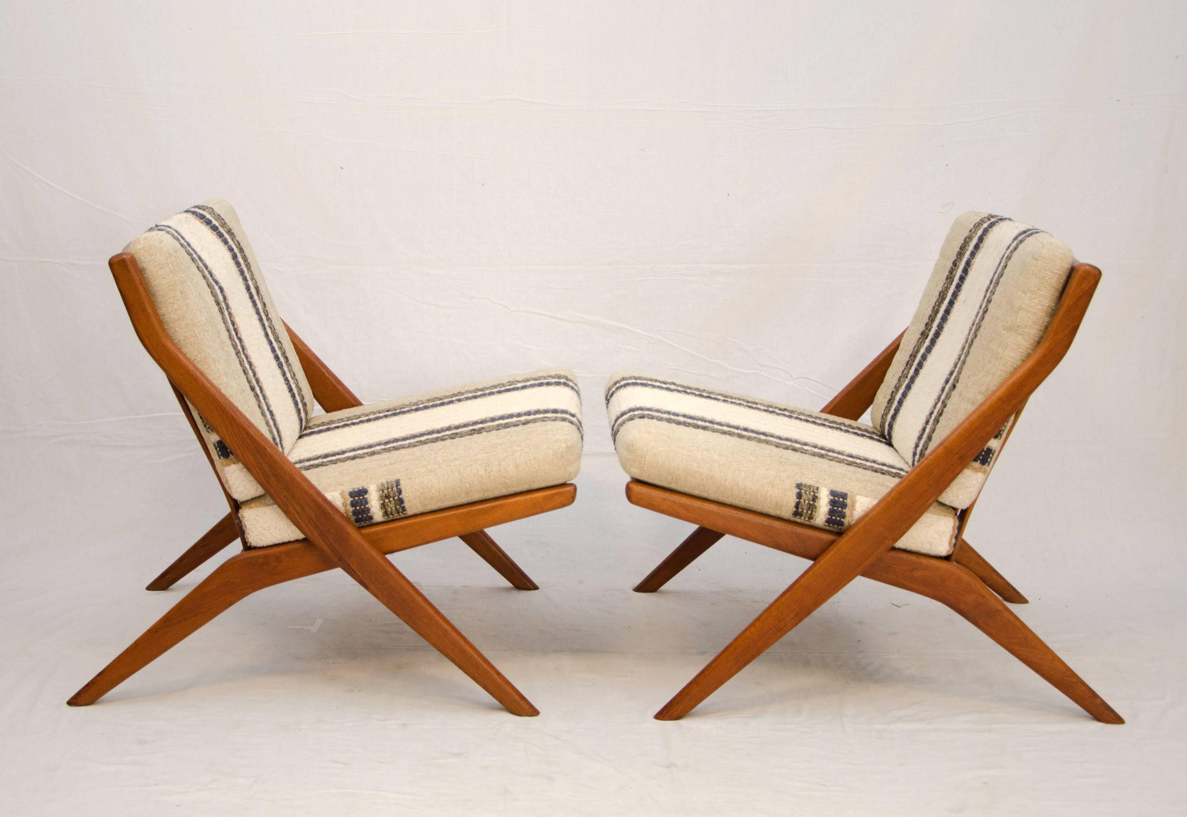 Very nice pair of DUX lounge chairs with a scissor profile. They can be placed side by side to create a loveseat as well as a more separated placement. Original upholstery with some minor wear at the top corners of the back cushions. Both chairs