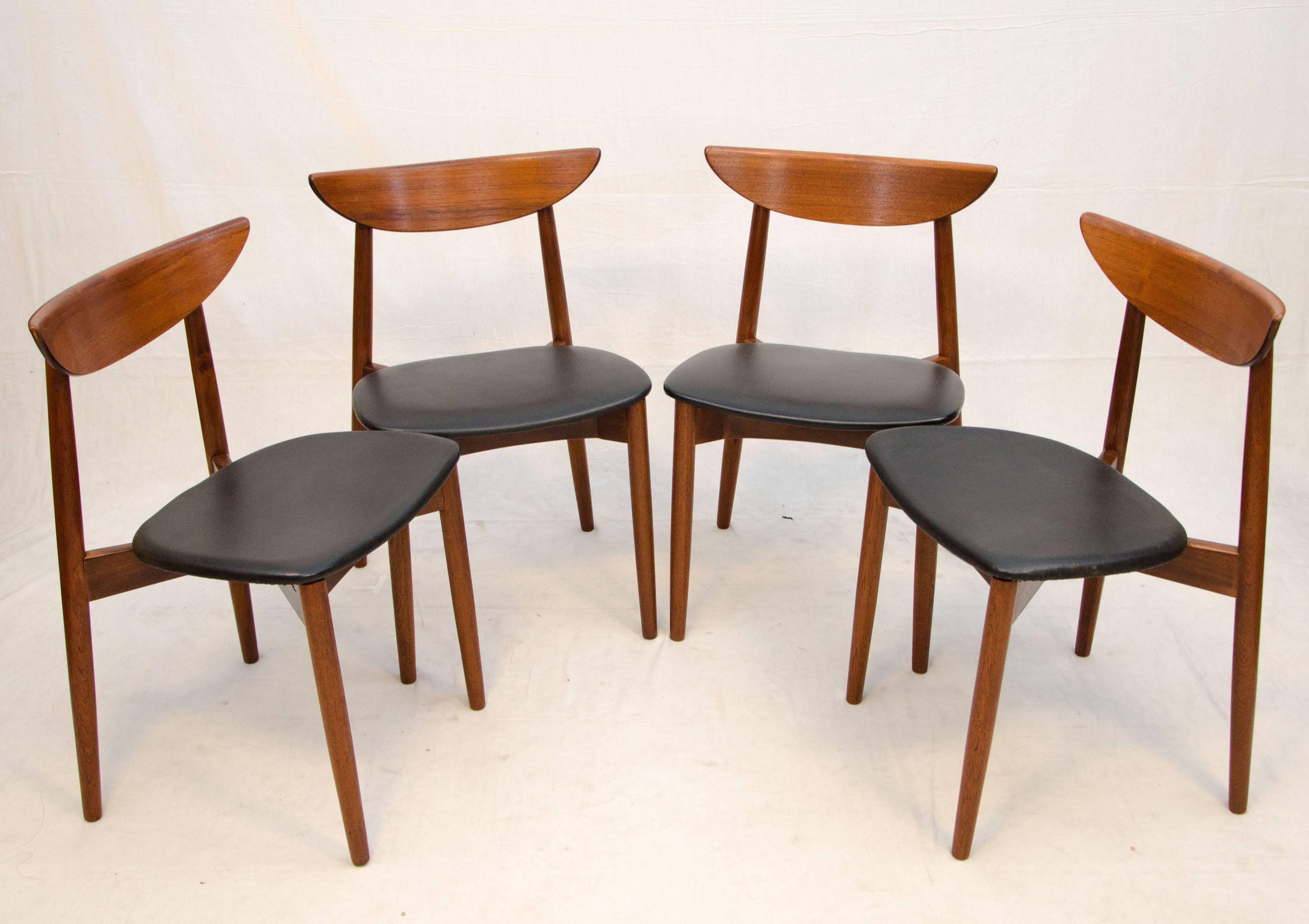 Stylish set of four Danish teak dining chairs designed by Harry Ostergaard for Moreddi. These chairs are uniquely accented by a tapered curved ledge that runs at the top of each back. The upholstered seats are original and easily detached for