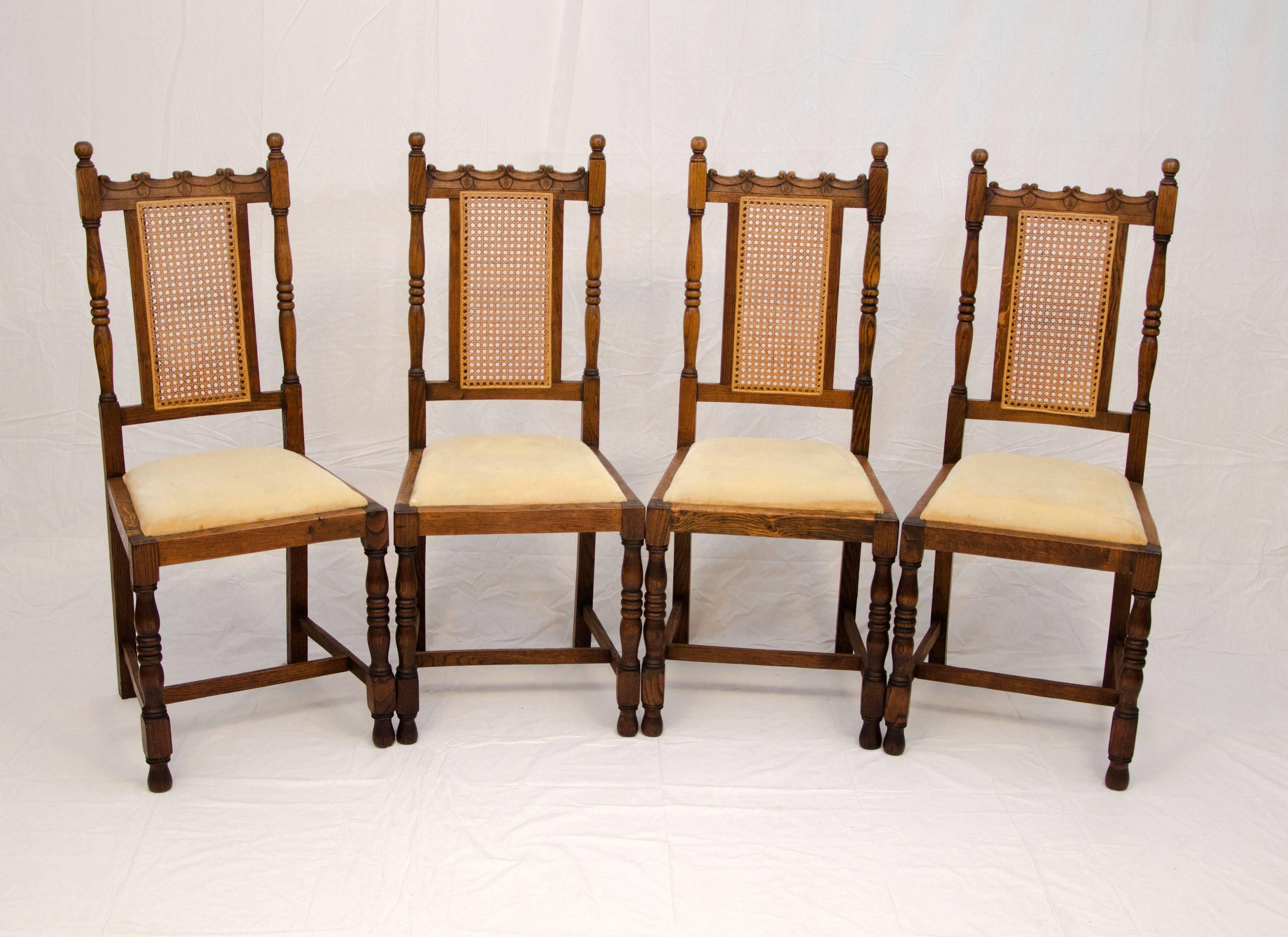 Good looking set of four antique English oak dining chairs with turned legs and accented by a cane back. These chairs were originally hand caned but were restored with sheet cane and spline, a spline is also attached to the backs to cover original