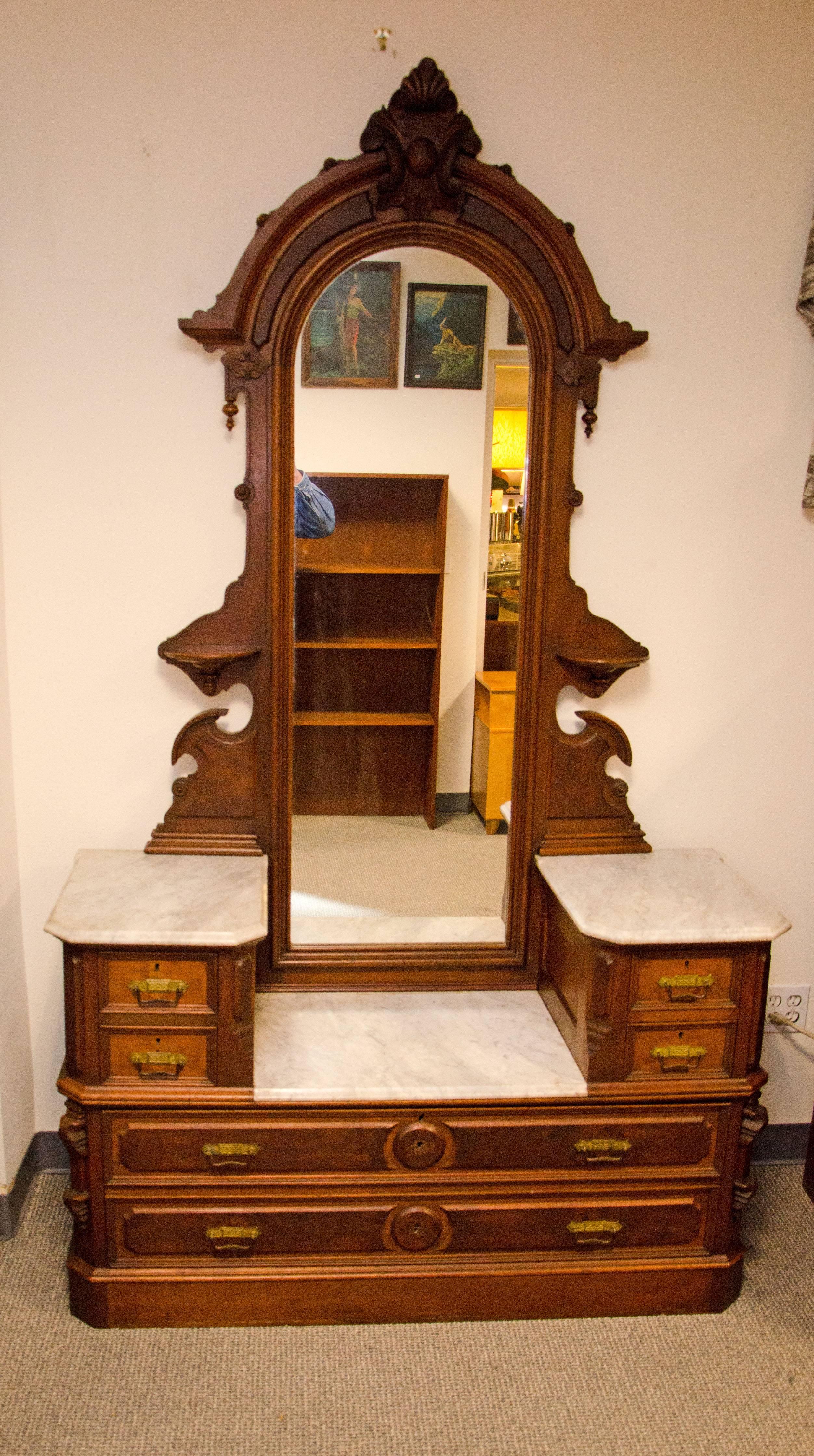Nice American Victorian drop well dresser with original finish, original marble, and mirror. It exhibits brass Eastlake style drawer pulls which may have been replacements for broken carved walnut handles by the previous owner, there are also some