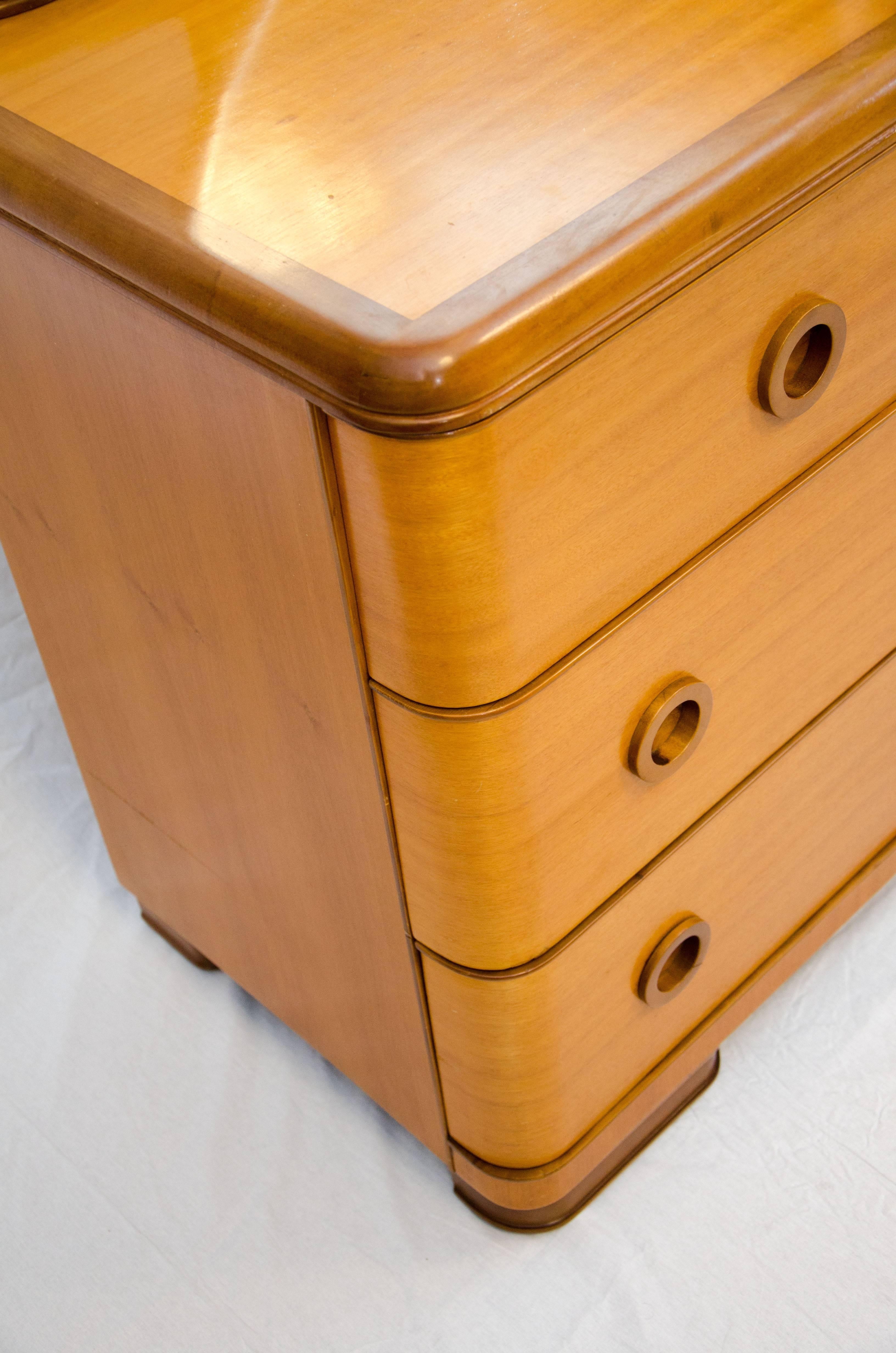  Blonde mahogany dresser with darker accents, rounded edges, inset circular drawer pulls, and a round mirror with a wooden frame (mirror height is 68