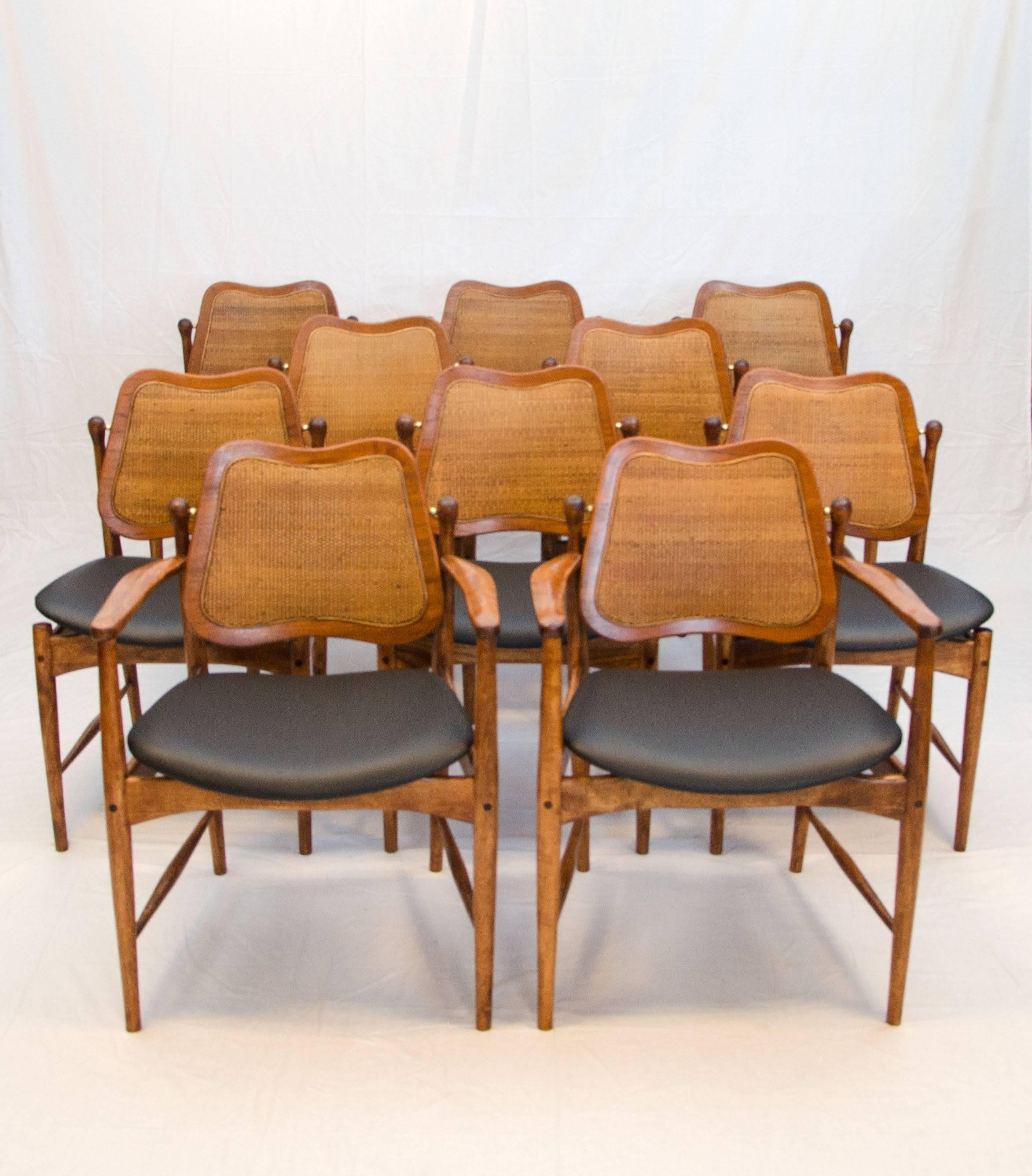 Rare set of ten Danish dining chairs designed by Arne Vodder. The teak backs retain the original caned inserts. The seats have a floating design in the way they attach to the frame. The swivel backs have a wooden crossbar behind them to keep them in