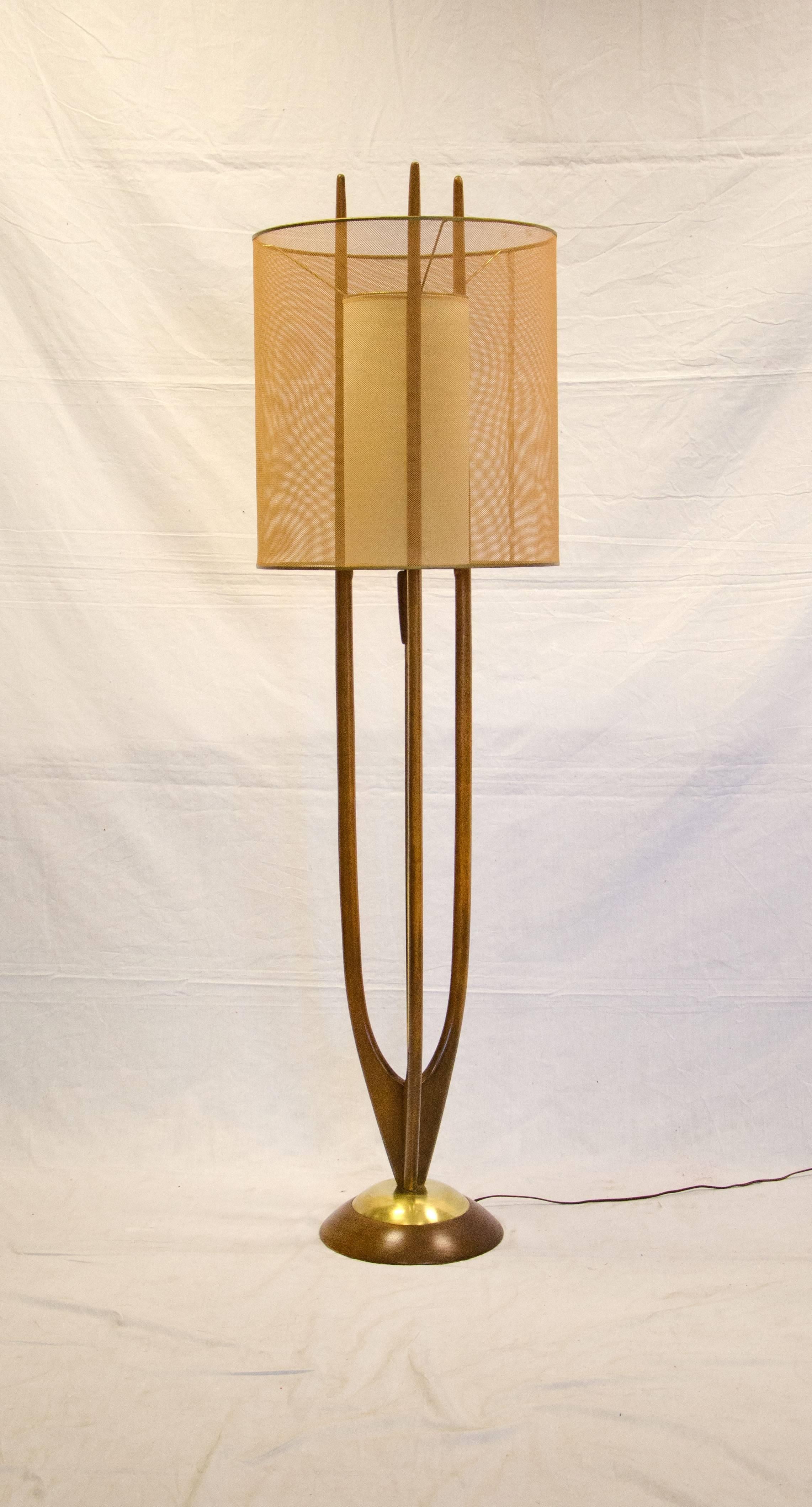 Wonderful Modeline floor lamp in great condition, retains both the original interior and exterior shades. On and off switch is located on the center brass rod. The interior shade is surrounded a by three prong wooden sculptural frame attached to a