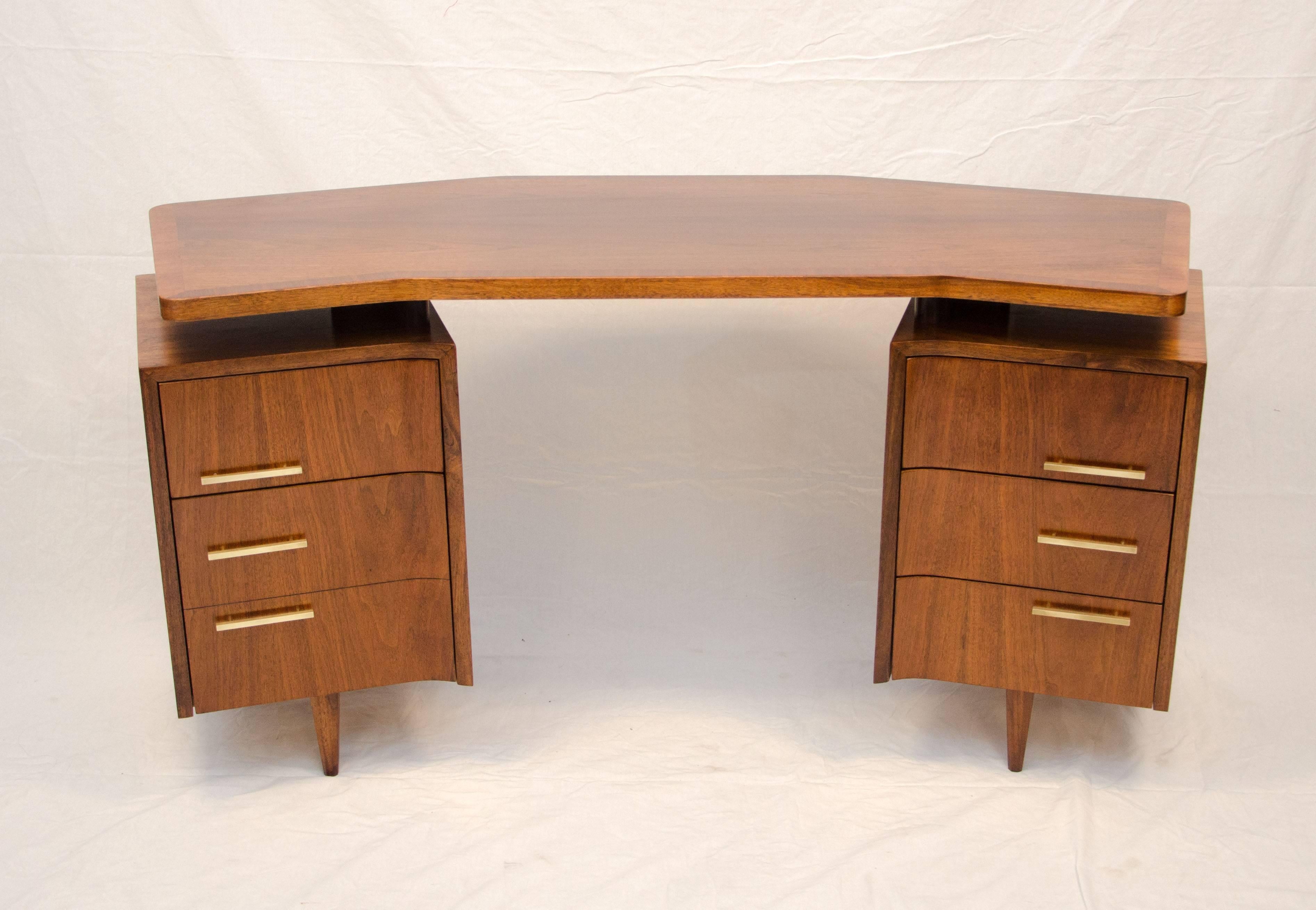 Unusual design mid century walnut curved writing desk with a floating top. The drawer pedestals are about an 1 1/2