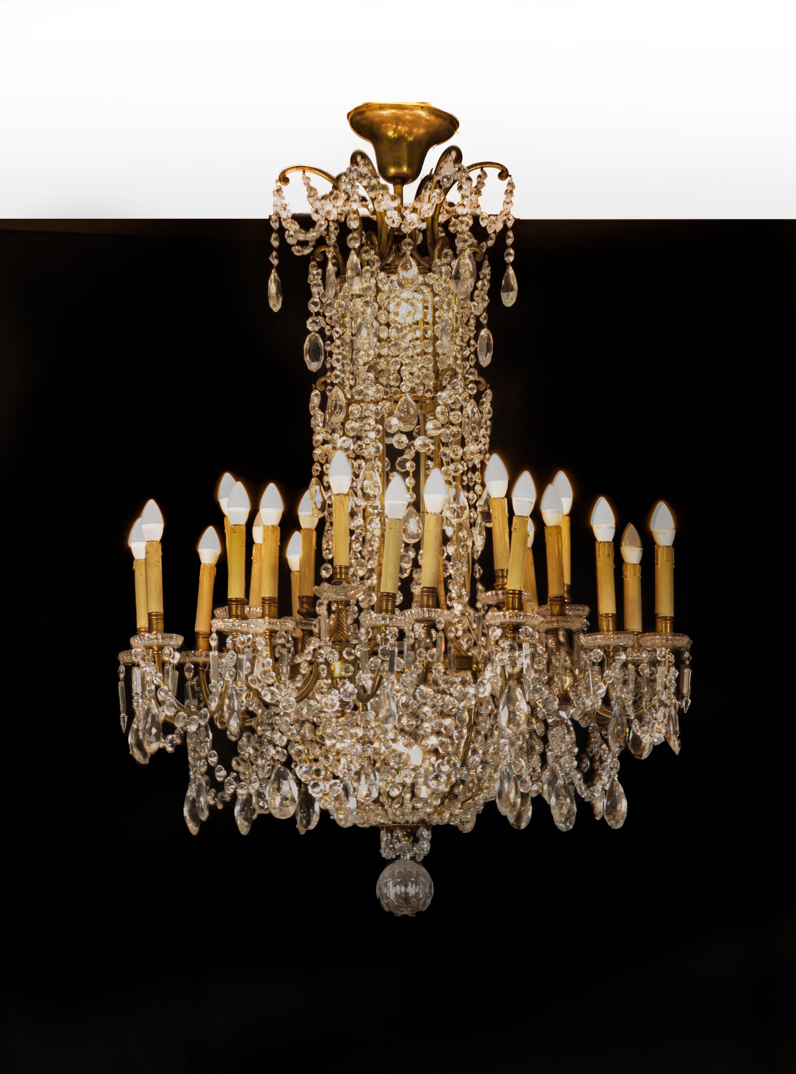 This Baccarat crystal and doré bronze chandelier of monumental size and opulent design is truly a splendid sight boasting 24 lights, distinguished by the oversized drops of crystals, which hang among garlands of luminous prisms from the doré bronze