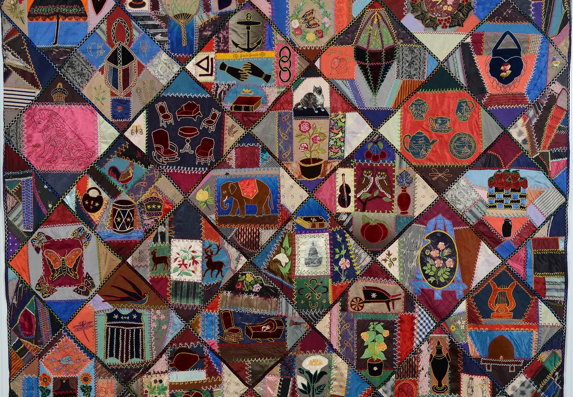 This contained crazy quilt has an extraordinary variety of appliqued and embroidered images. Animals include an elephant; deer; rooster; dog; cat; and horse.
It has a patriotic shield; eagle and flags. A printed image of the U.S. Capitol is in the