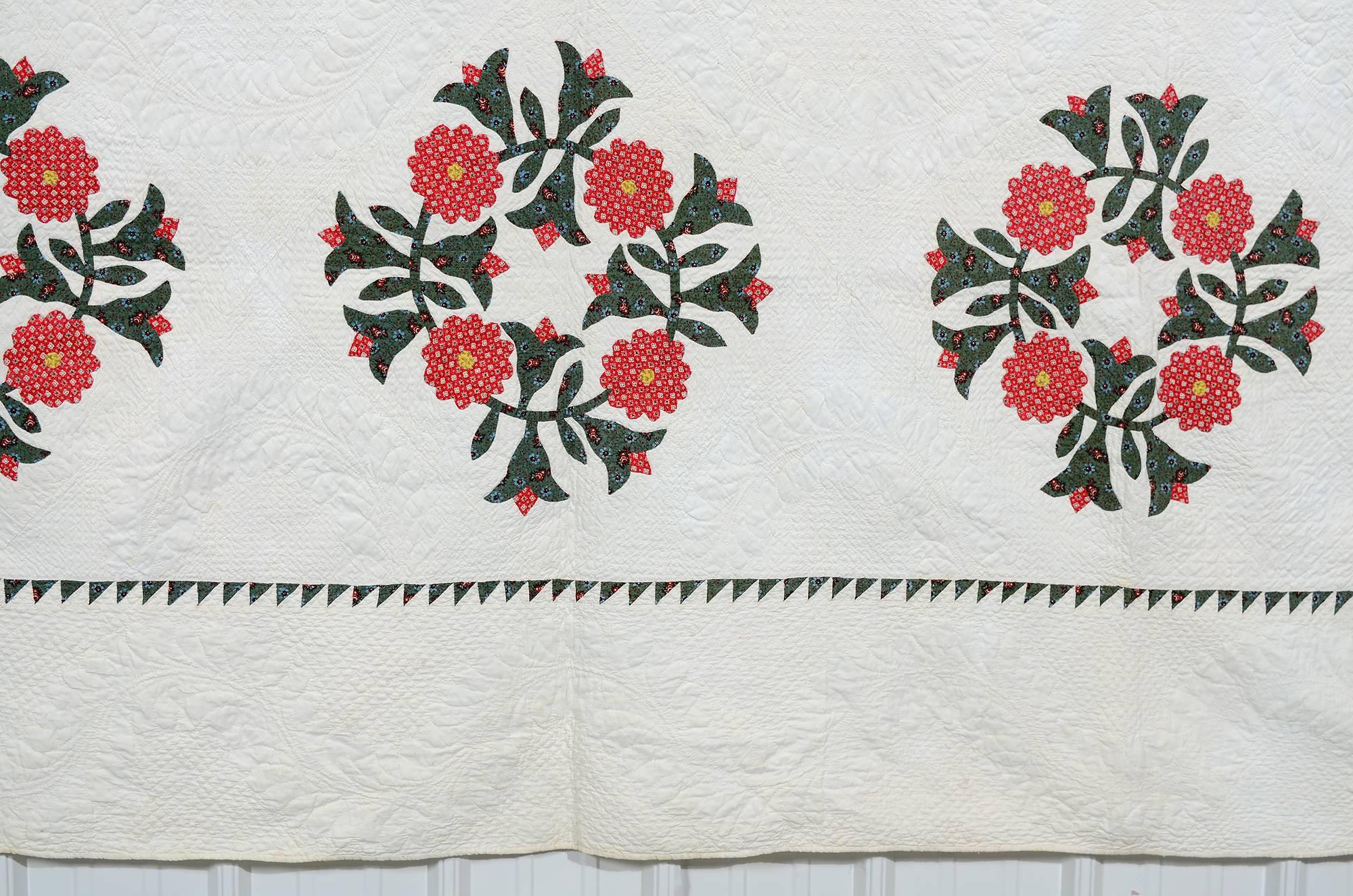 This Classic floral wreath applique quilt is exquisitely quilted. Detailed wreaths are stitched between each of the appliqued blocks. A tiny scale sawtooth border is further indication of the precision with which this quilt was made. It has been