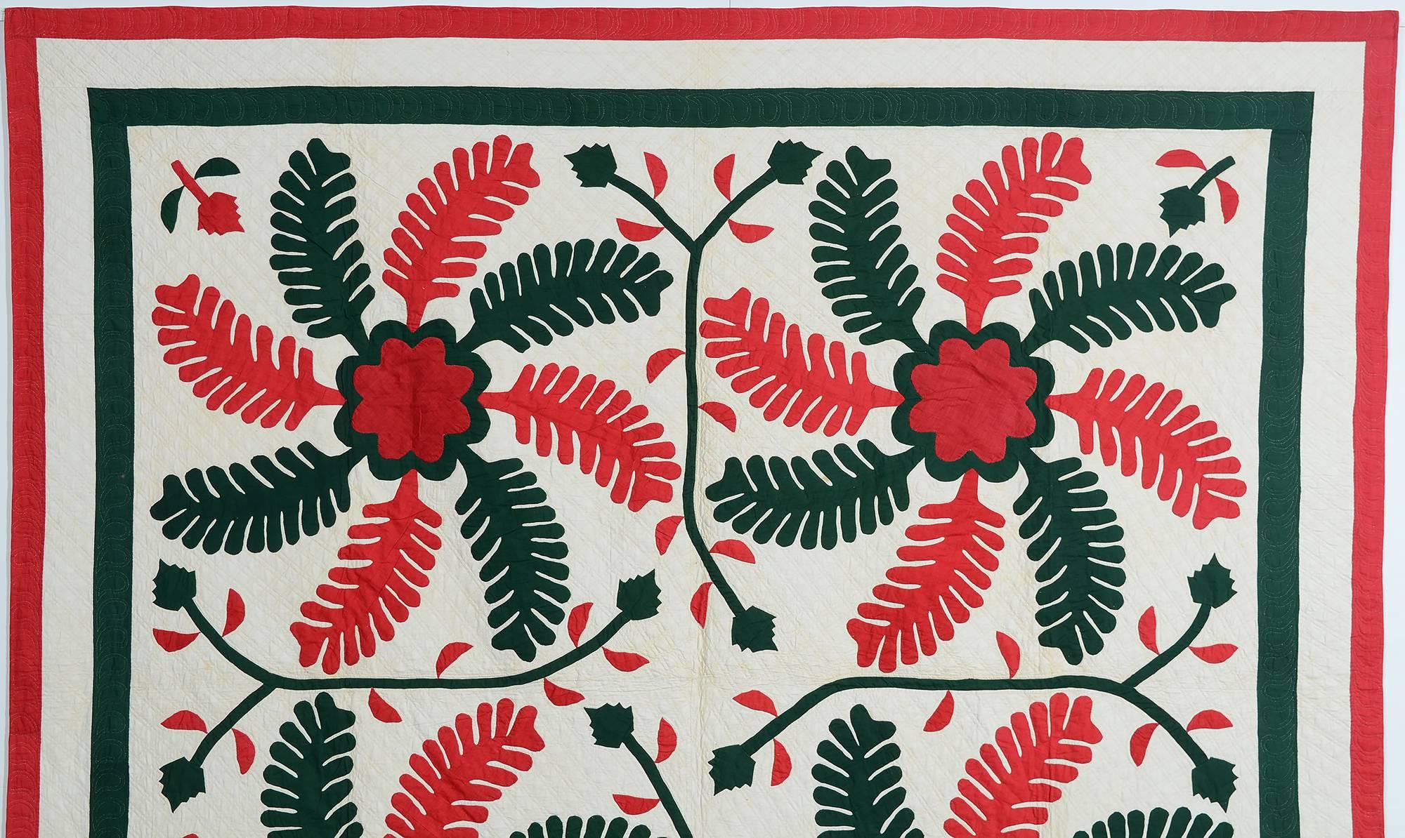 This princess feather quilt is particularly bold and vivacious. The floral center of each of the four feathers anchors the swirling arms. Most unusual are the vines and leaves separating the feathers.
It is very finely executed; quilted with double