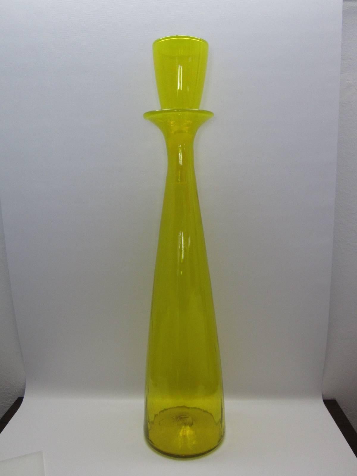 Large Jonquil Blenko architectural floor decanter with stopper by Wayne Husted. Tall blown glass with matching stopper. Very impressive in size and color makes a great statement.