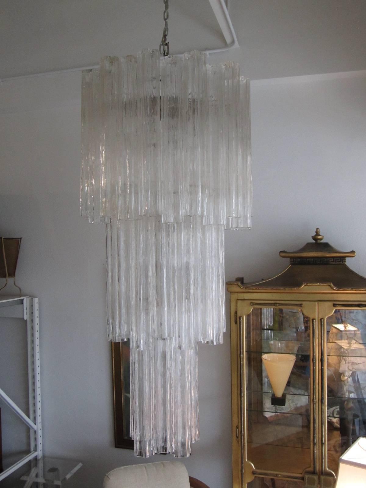 Gorgeous cascading three-tier chandelier made of hand blown Murano glass tronchi pendants designed by Venini. Chandelier takes 11 standard-base 60 Watt max bulbs and was rewired to US Standards. Chrome frame in original condition shows ware only