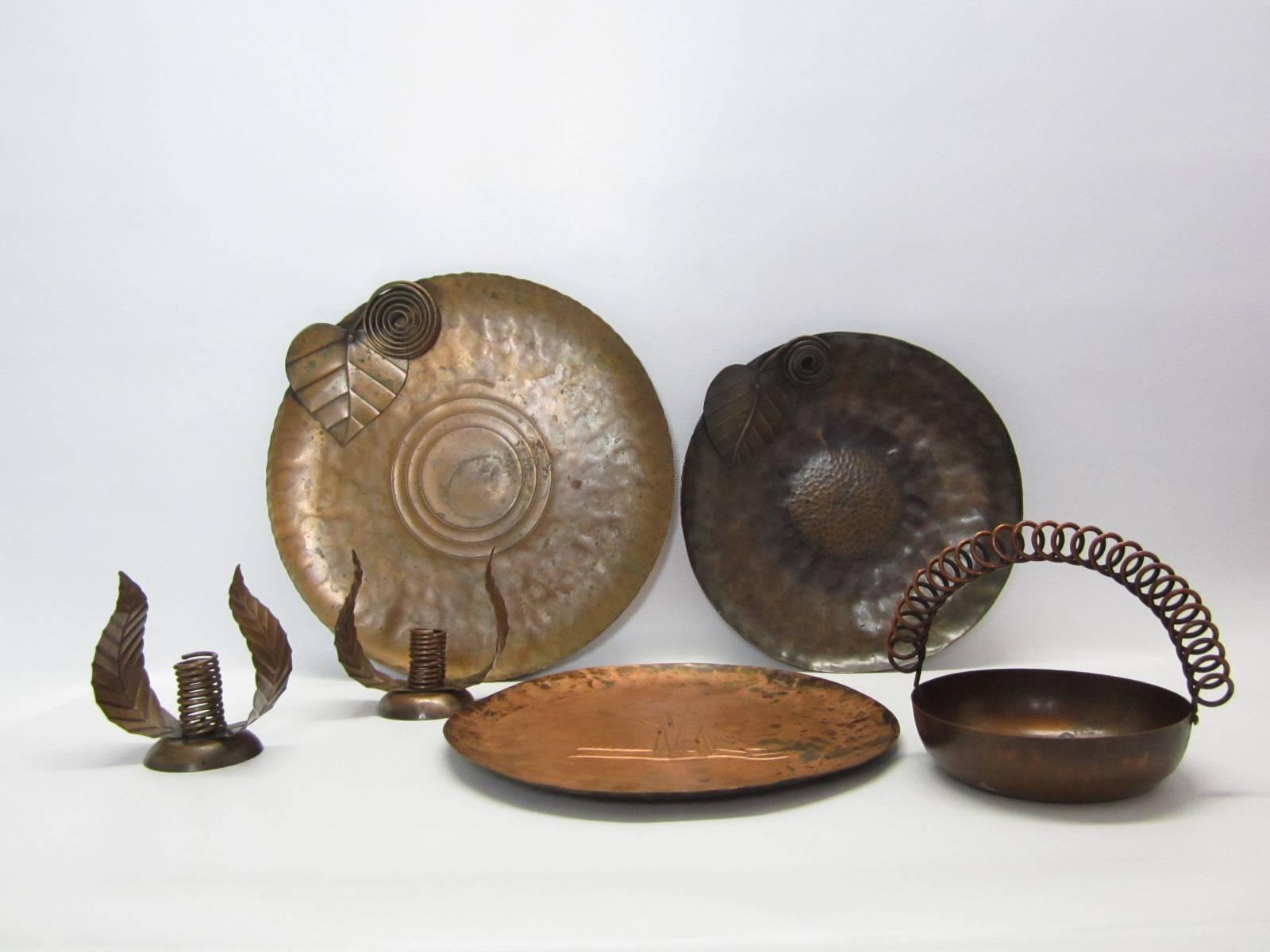 Grouping of hand-hammered and hand-wrought decorative pieces from a master jewelry and house wares artist and designer. Group consists of large platter with leaf and coil design, smaller leaf and coil plate, plate with hammered ship motif, bowl with
