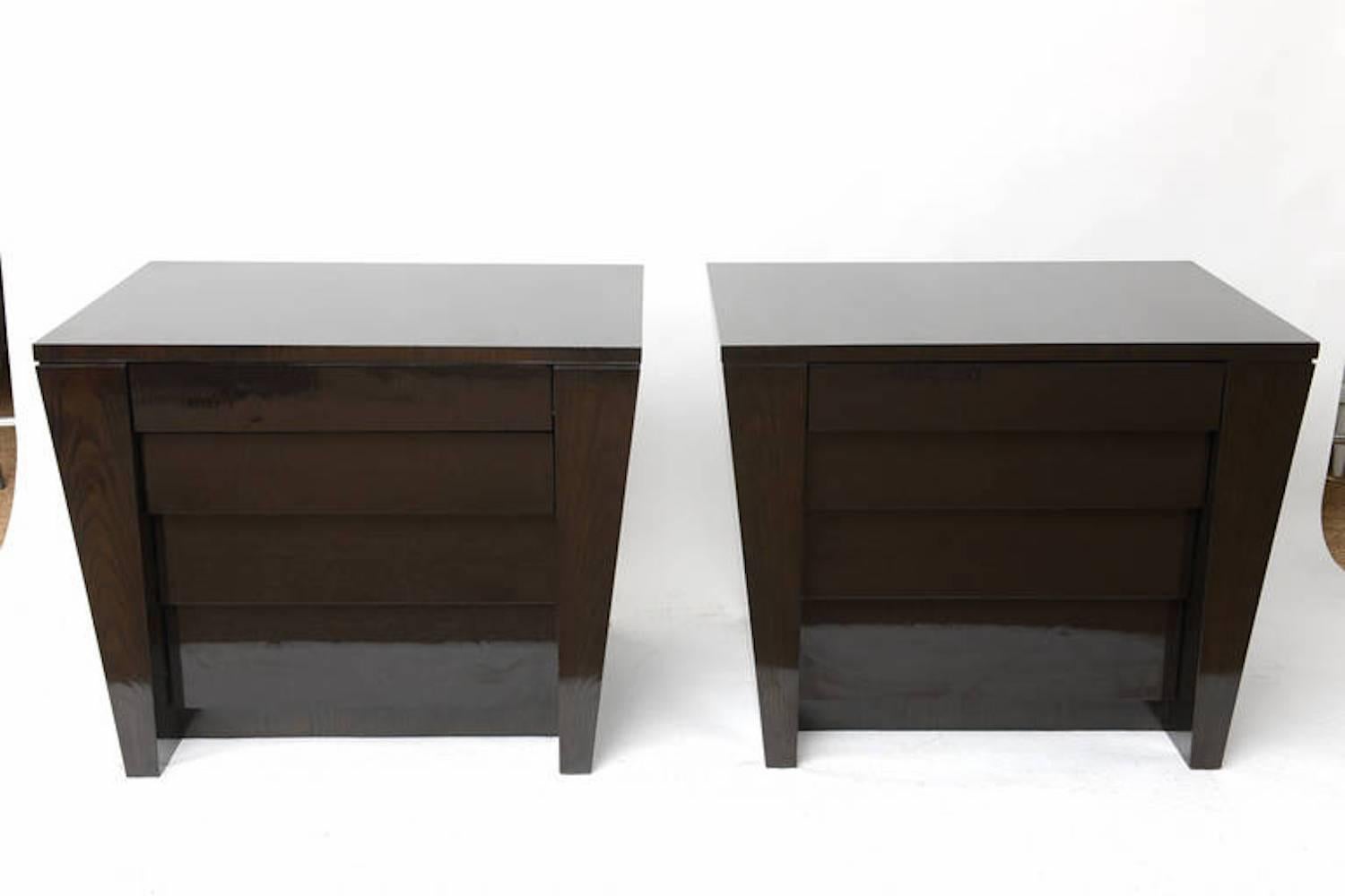 Pair of ebonized oak chests that taper on the sides and are inverted in the front. Four drawers each on gliders. The ebony is completed with a high gloss clear coat. Stunningly finished inside and out. These function both as chests of drawers and