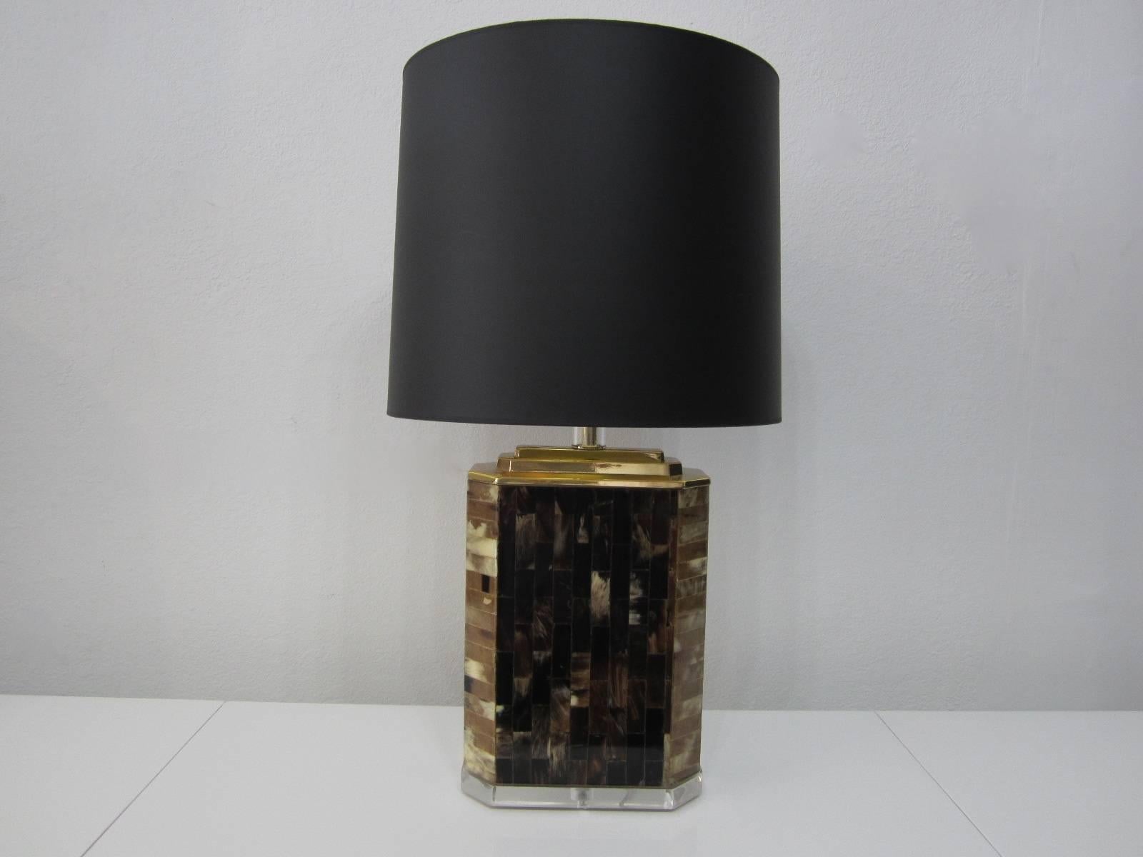 Tabletop lamp fashioned of individual sliced horn inlaid tiles with lucite base and triple tier brass top with lucite encased brass neck. Newly rewired and appointed in brass. Sold with or without gold interior black paper shade. Height to socket